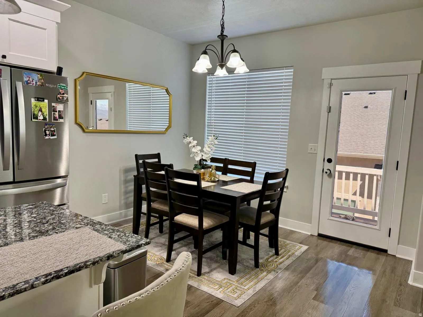 Dining room with hanging lights and dark wood-style floors