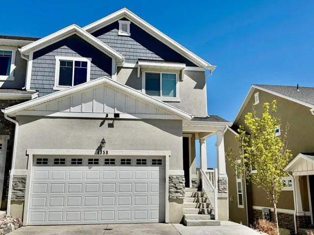 Craftsman house featuring board and batten siding, stone siding, concrete driveway, a porch, and stucco siding