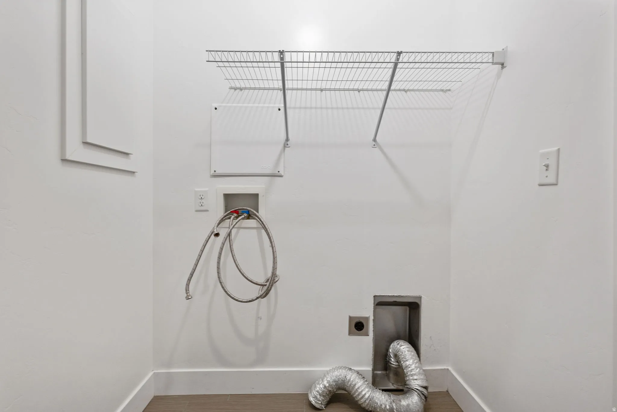 Laundry room with hookup for a washing machine, hookup for an electric dryer, and wood finished floors