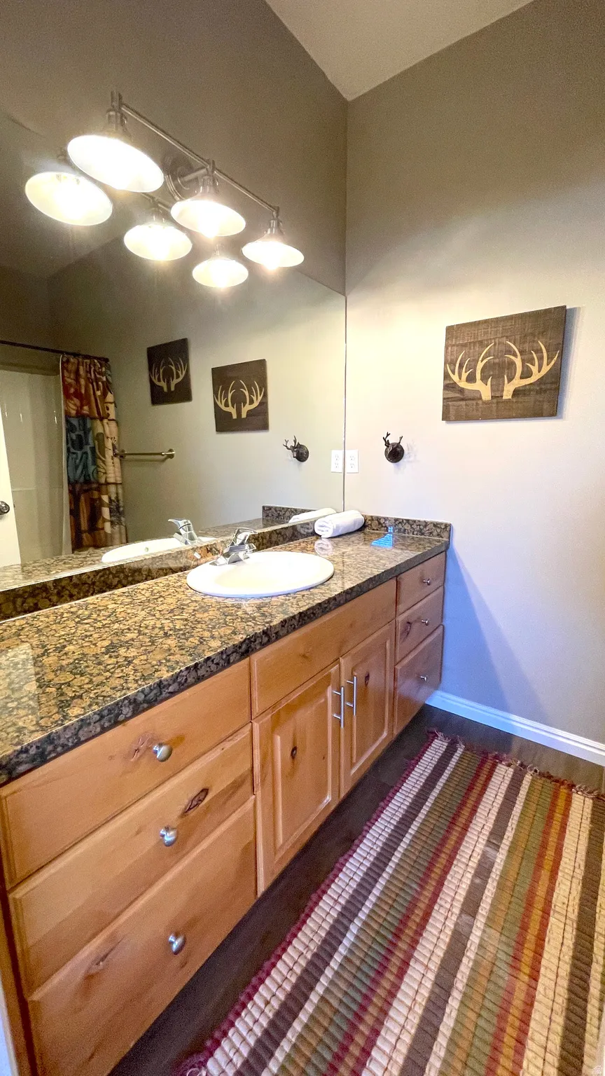 Primary suite full bath featuring vanity and curtained shower