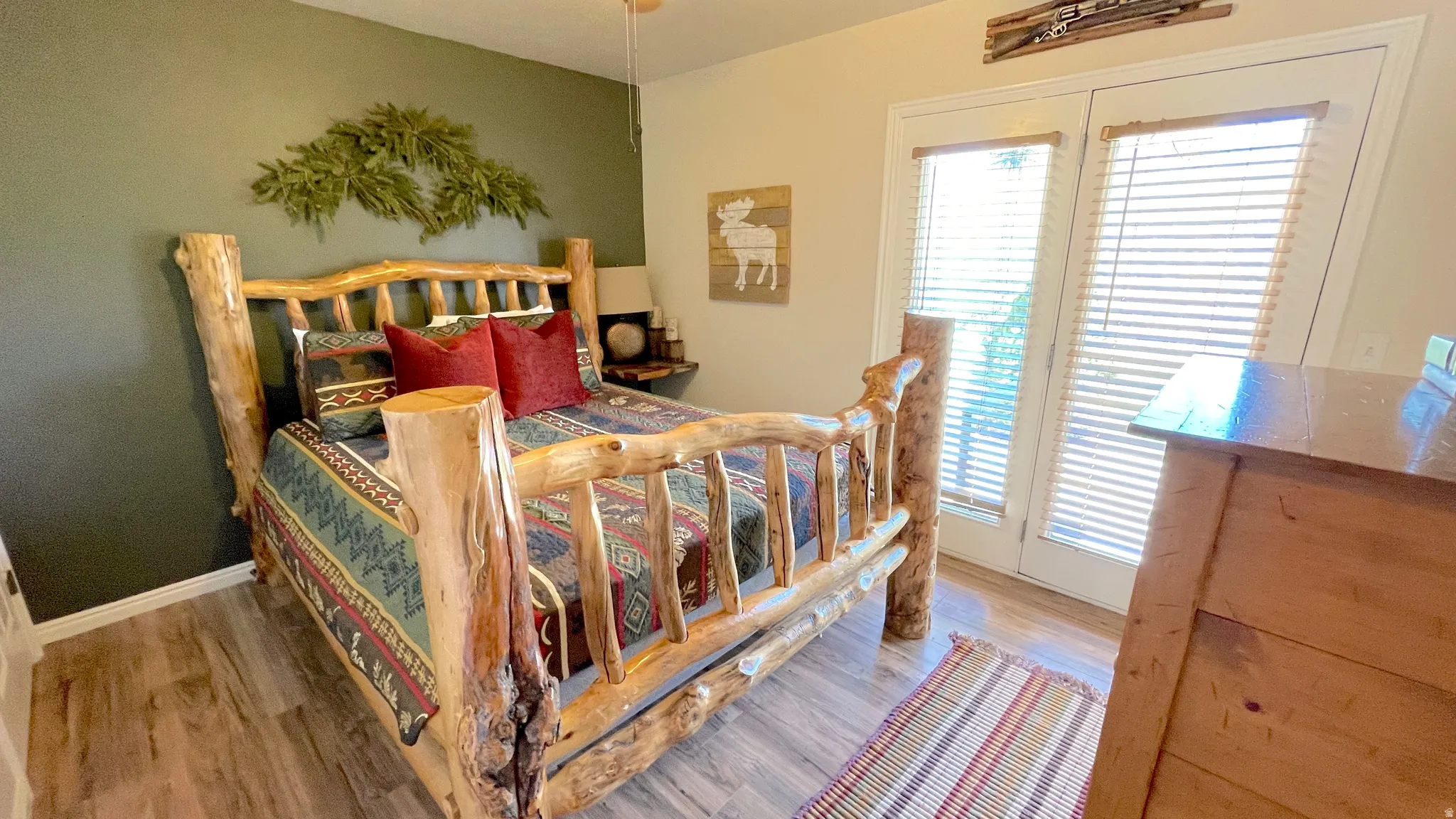 Main level bedroom featuring light wood-type flooring and access to east-facing outside patio