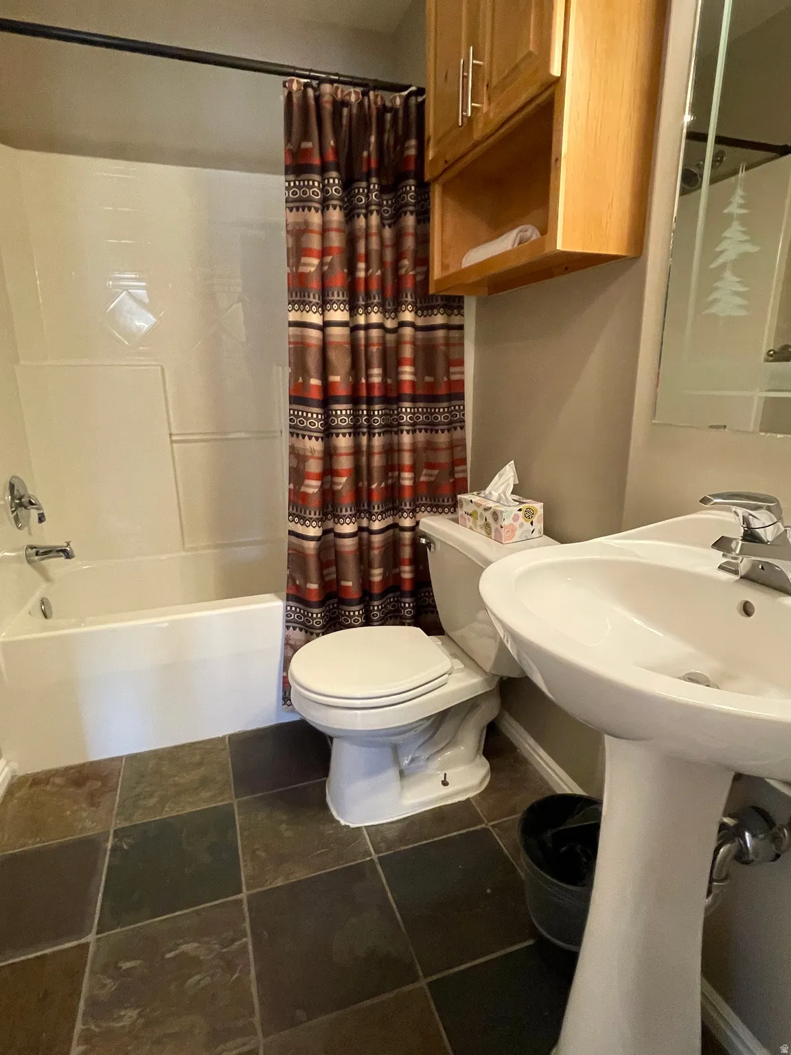 Full main bathroom featuring toilet and shower / bath combination with curtain
