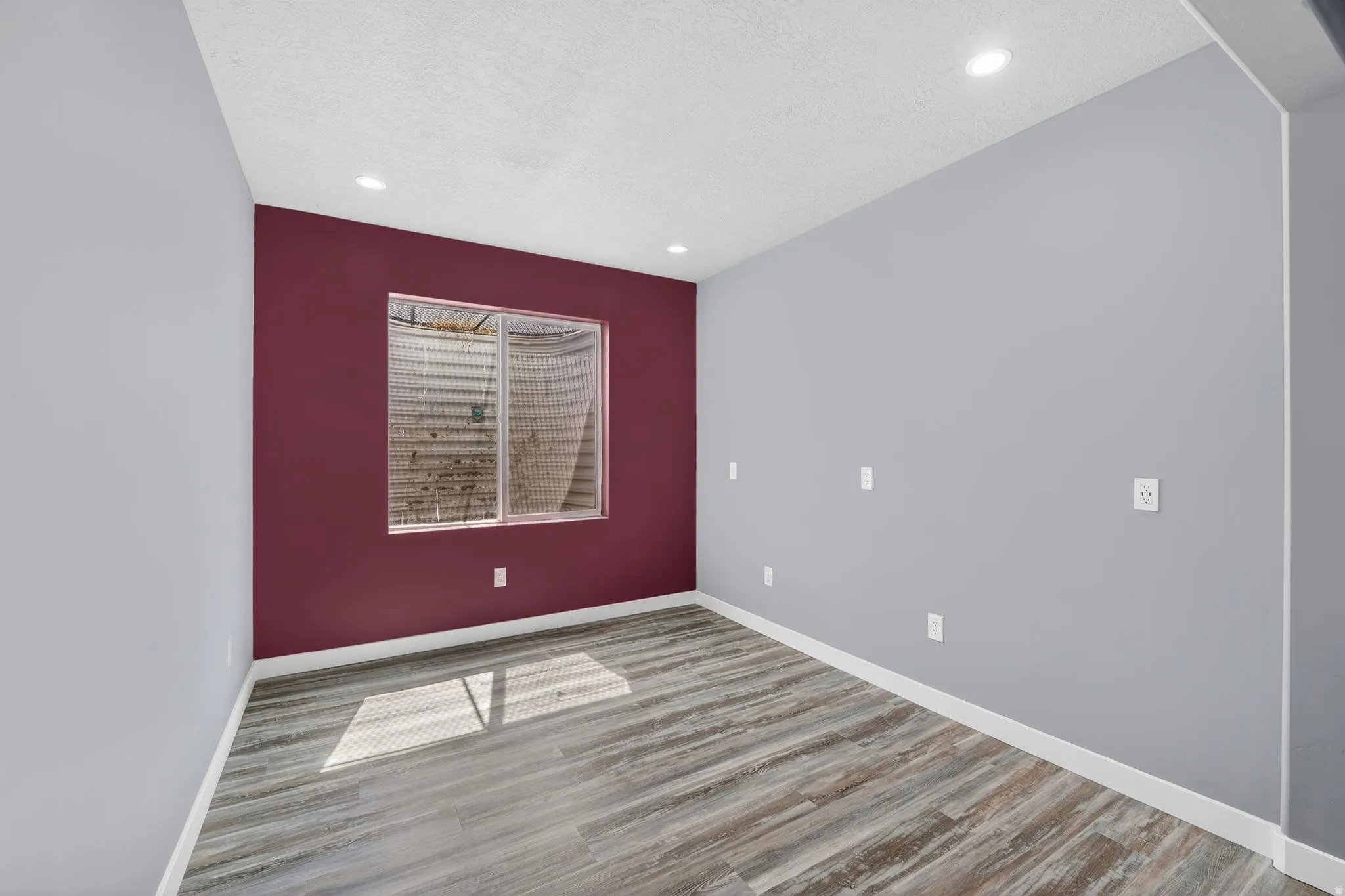 Unfurnished room featuring light wood finished floors, recessed lighting, and a textured ceiling