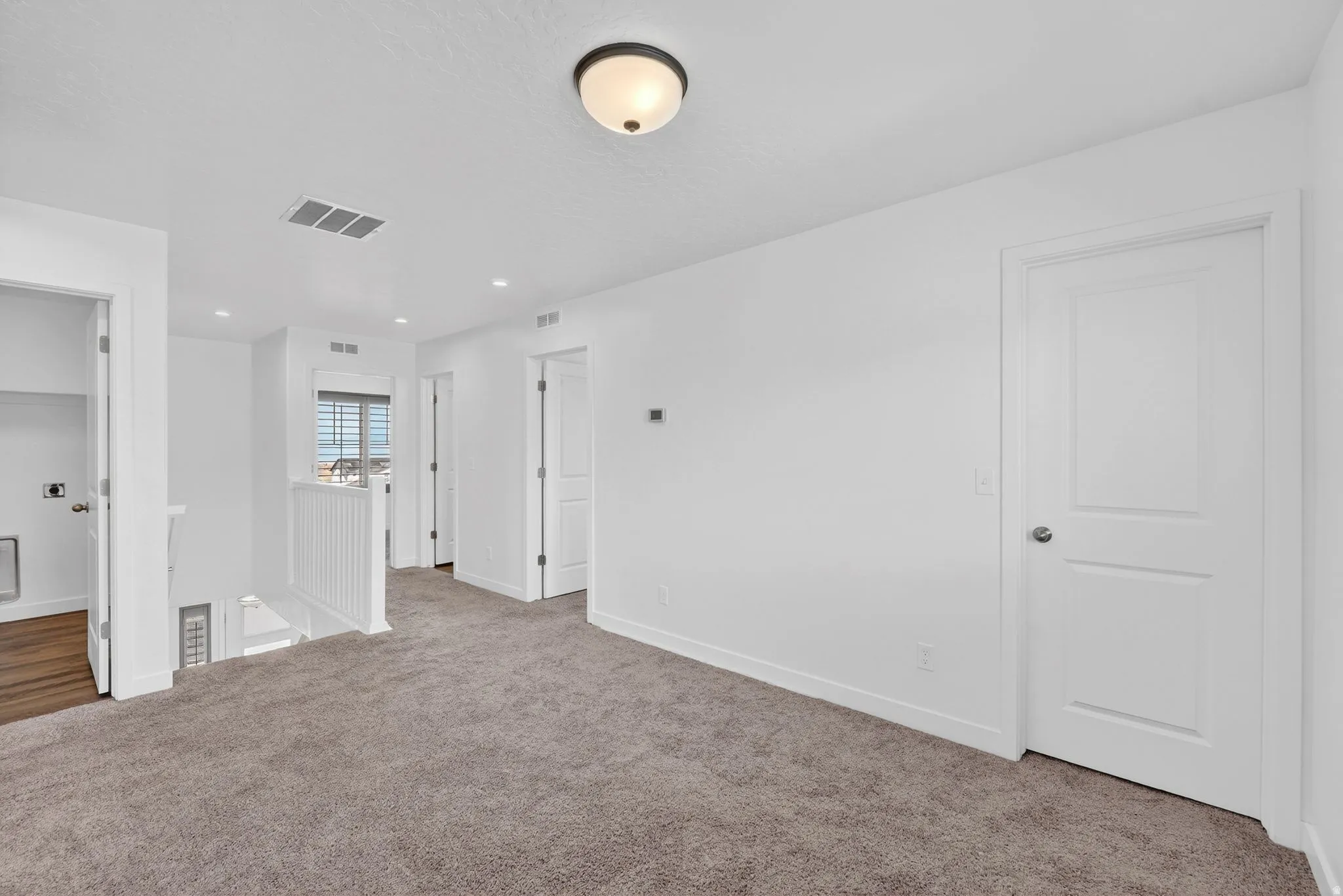 Carpeted spare room featuring baseboards and recessed lighting
