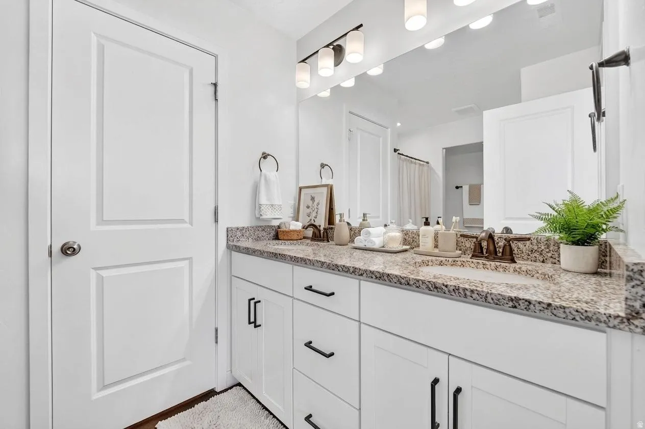 Full bathroom featuring double vanity and a shower with curtain