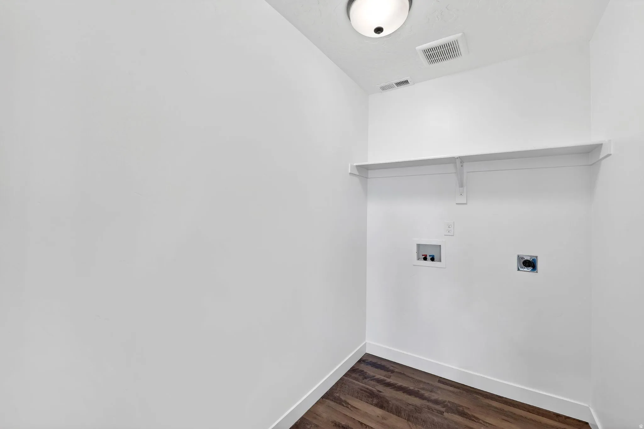 Laundry room featuring dark wood-style floors, electric dryer hookup, and hookup for a washing machine