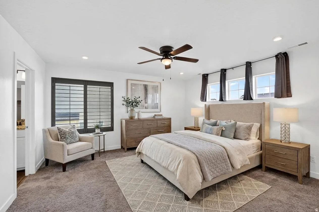 Carpeted bedroom with a ceiling fan and recessed lighting