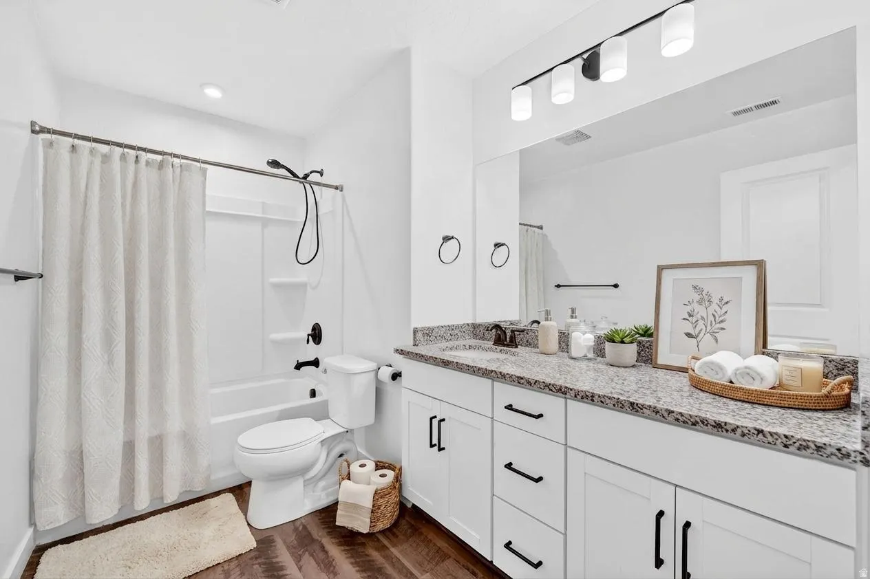 Bathroom featuring vanity, dark wood-style flooring, and shower / tub combo