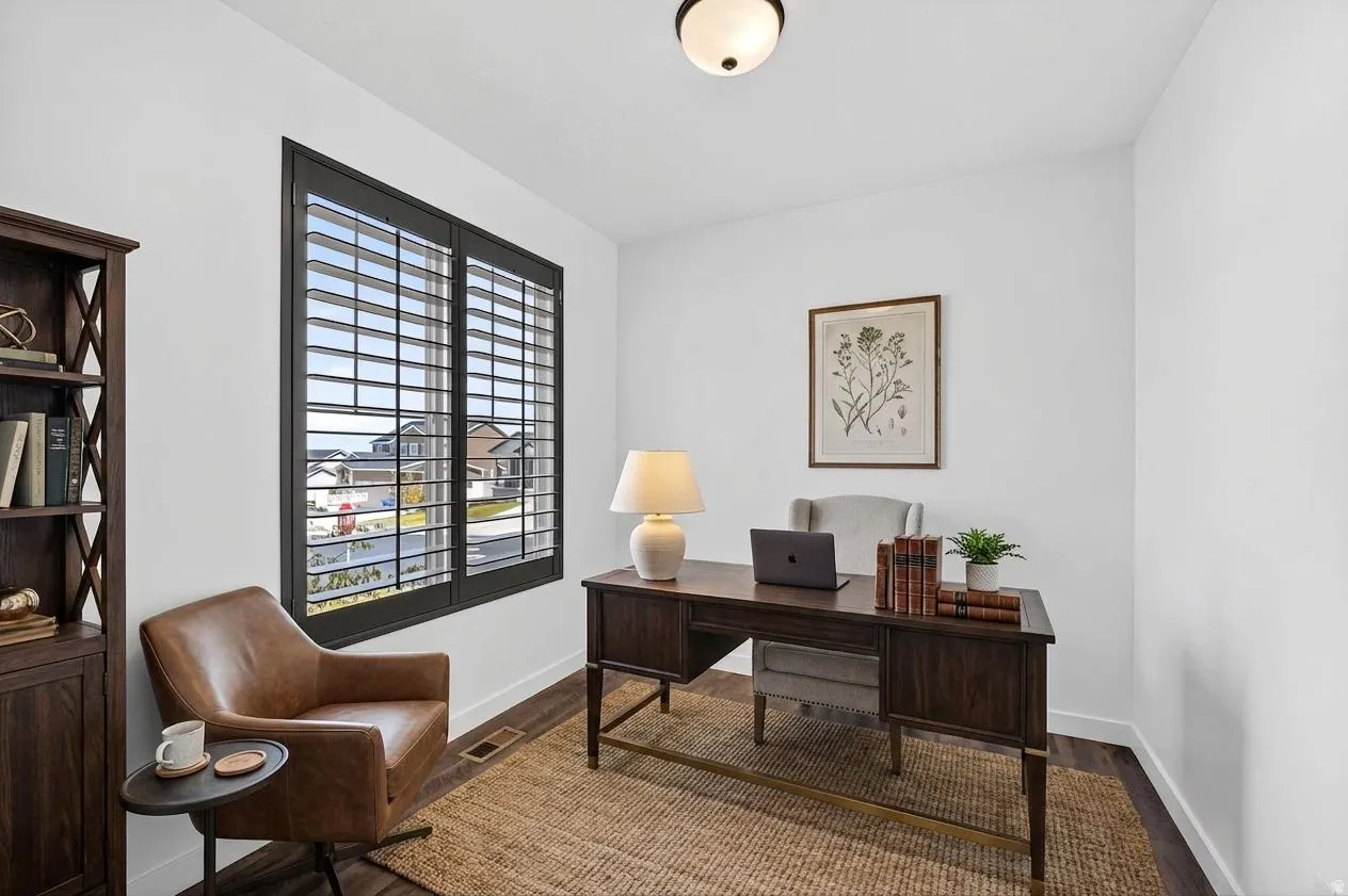 Home office right off the entry, featuring baseboards and wood finished floors