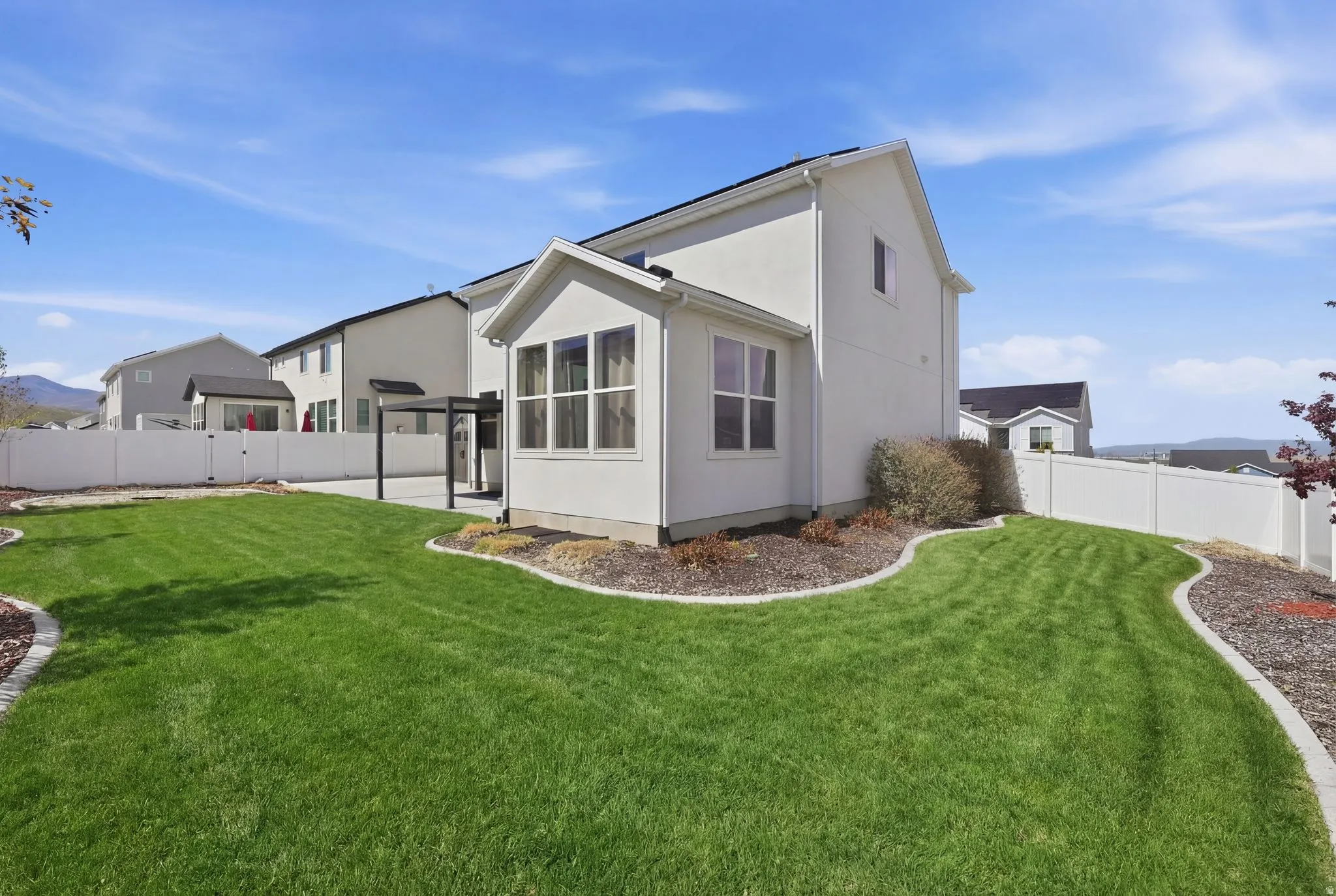 Rear view of house with a fenced backyard, stucco siding, and a mountain view