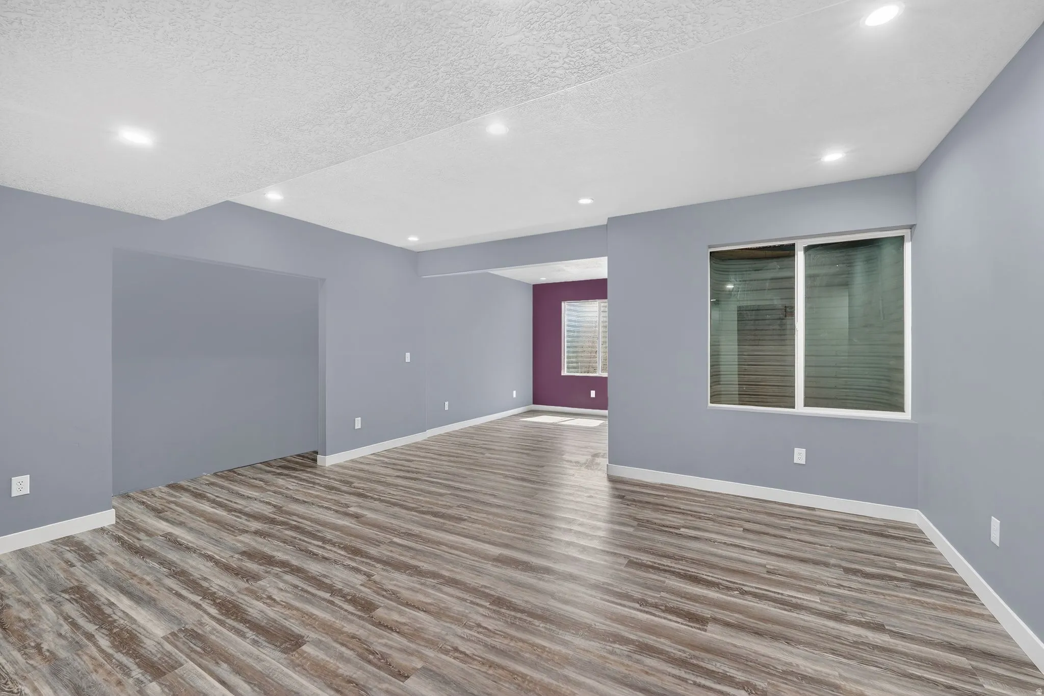 Empty room featuring a textured ceiling, light wood finished floors, and recessed lighting