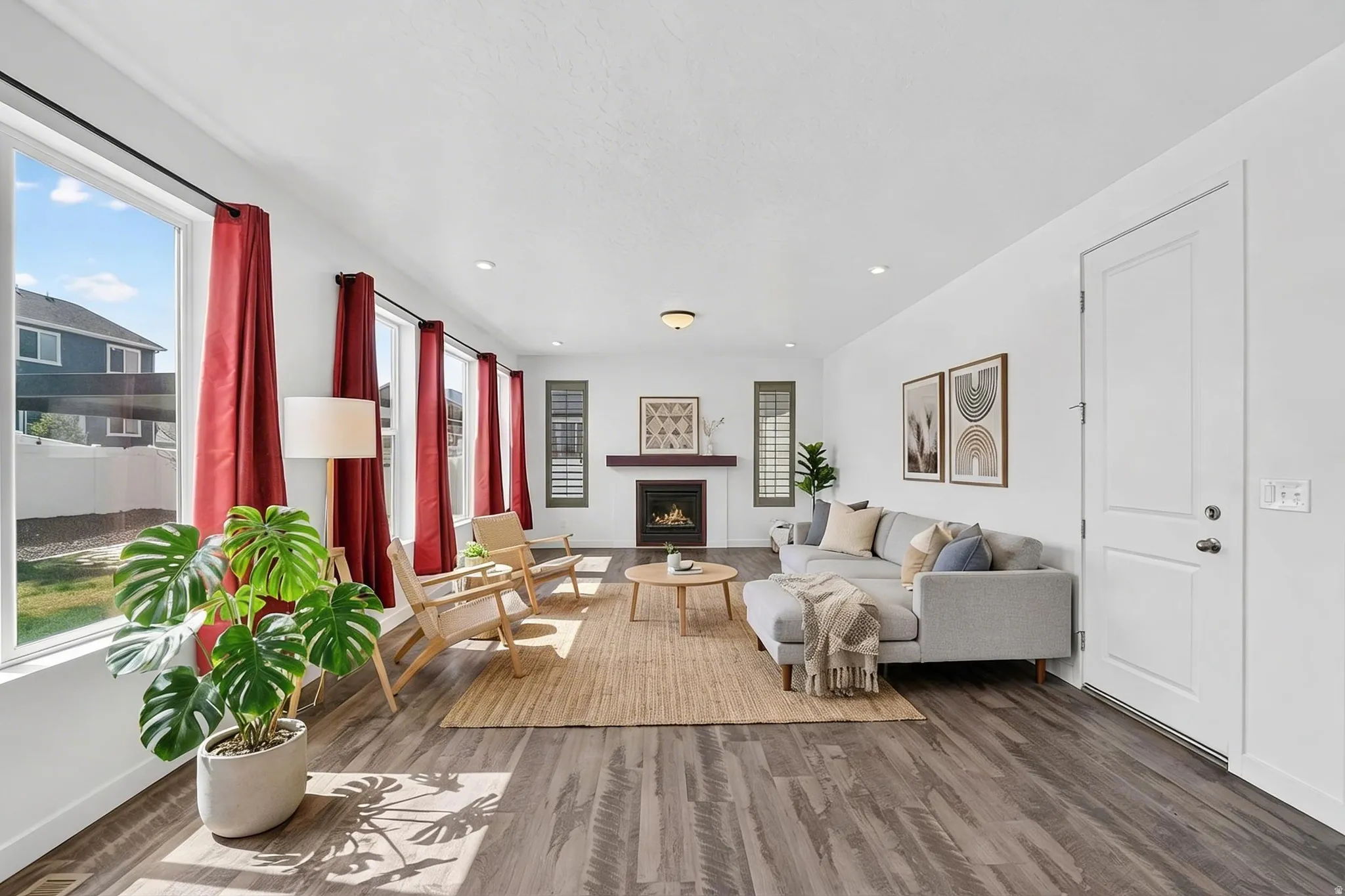 Living area featuring a warm lit fireplace, wood finished floors, healthy amount of natural light, and recessed lighting