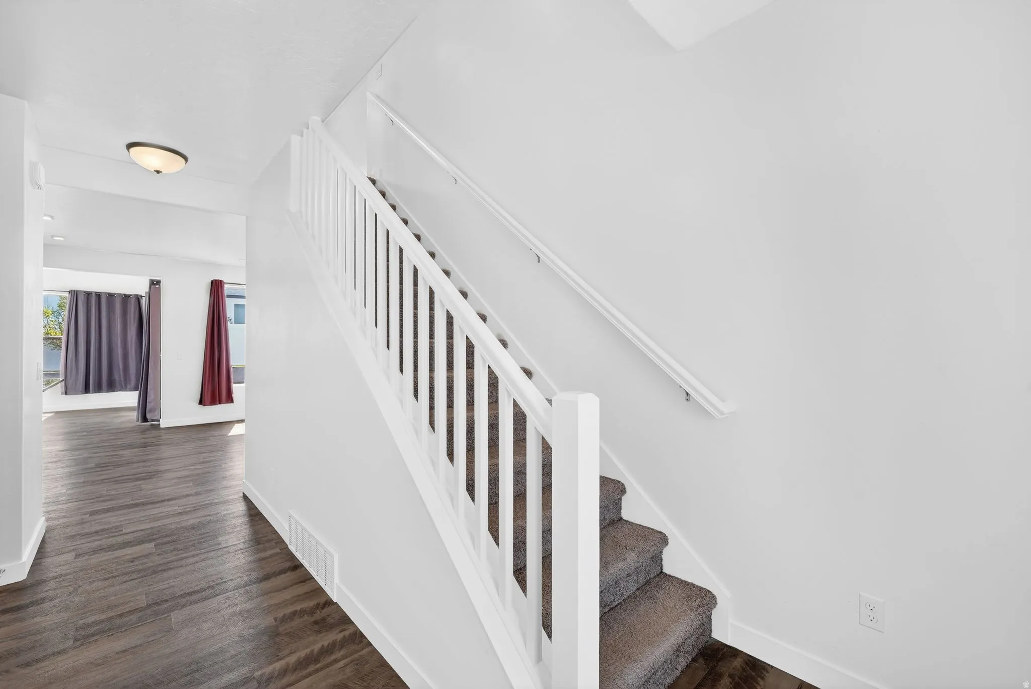 Stairs with wood finished floors and baseboards