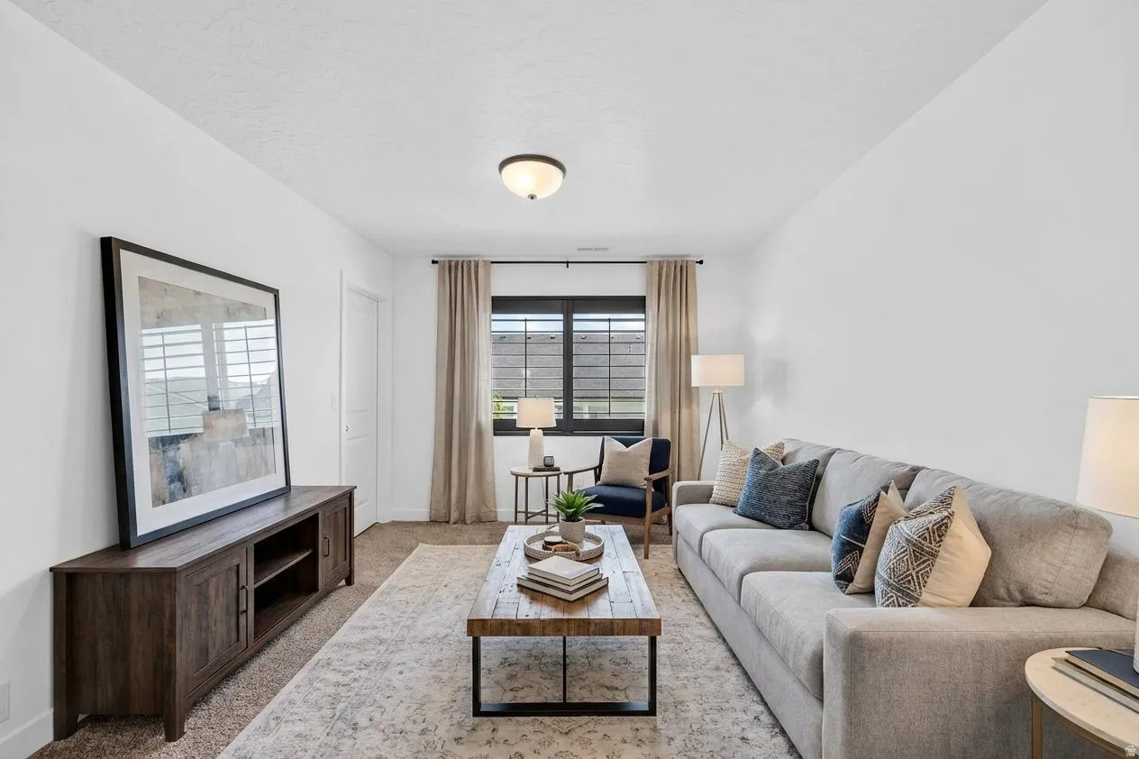 Living area with light colored carpet and baseboards