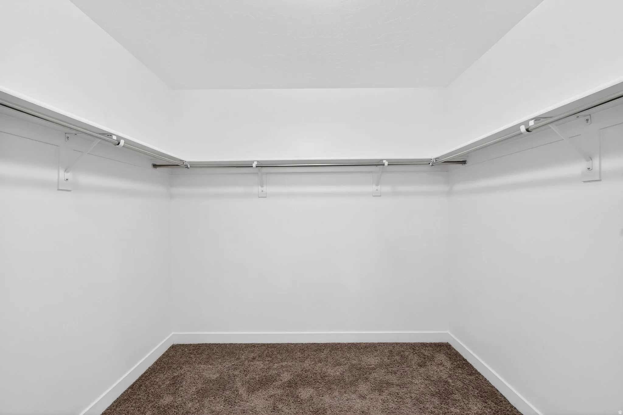 Walk in closet with dark carpet