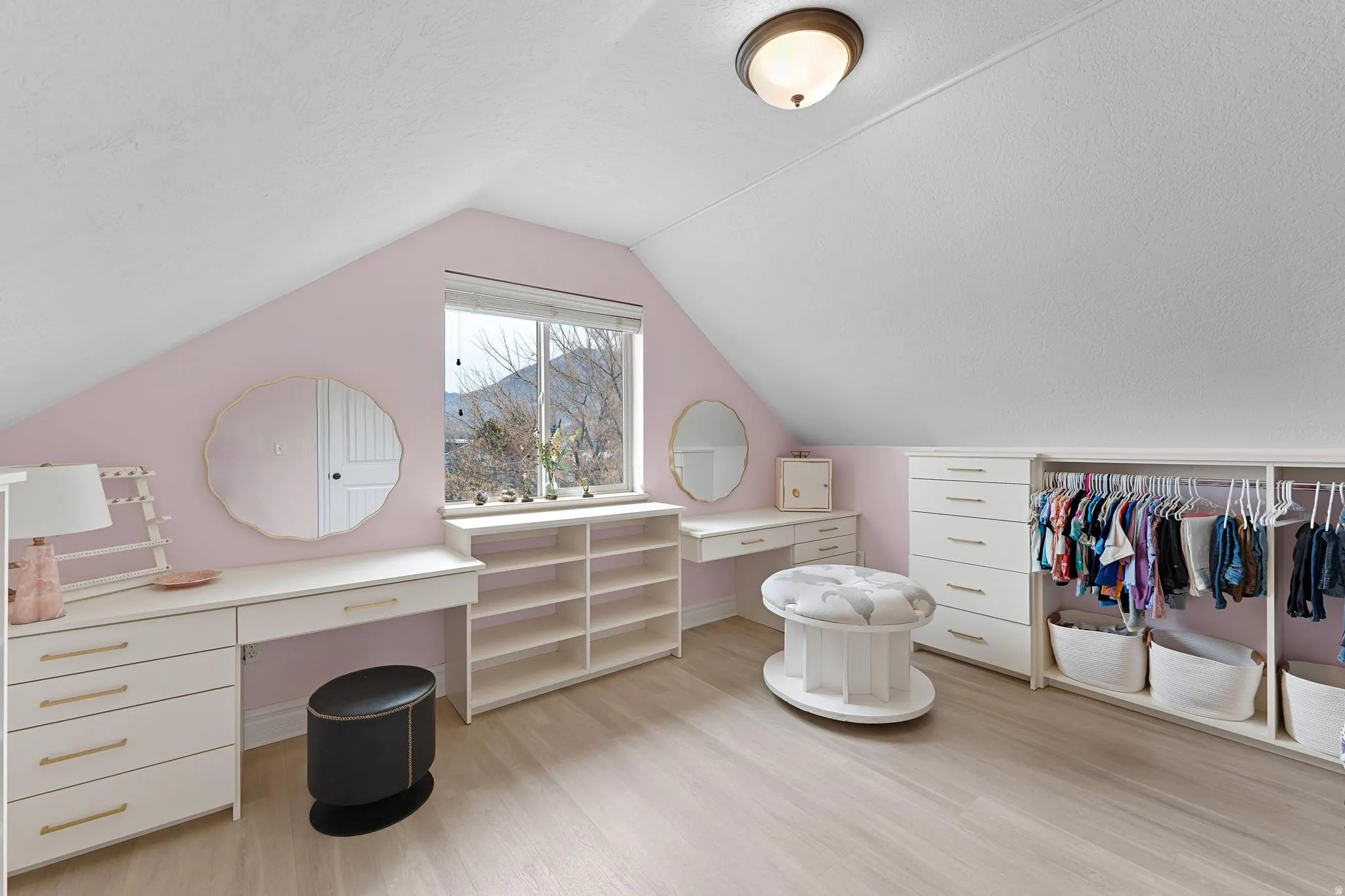 Walk in closet with light wood finished floors