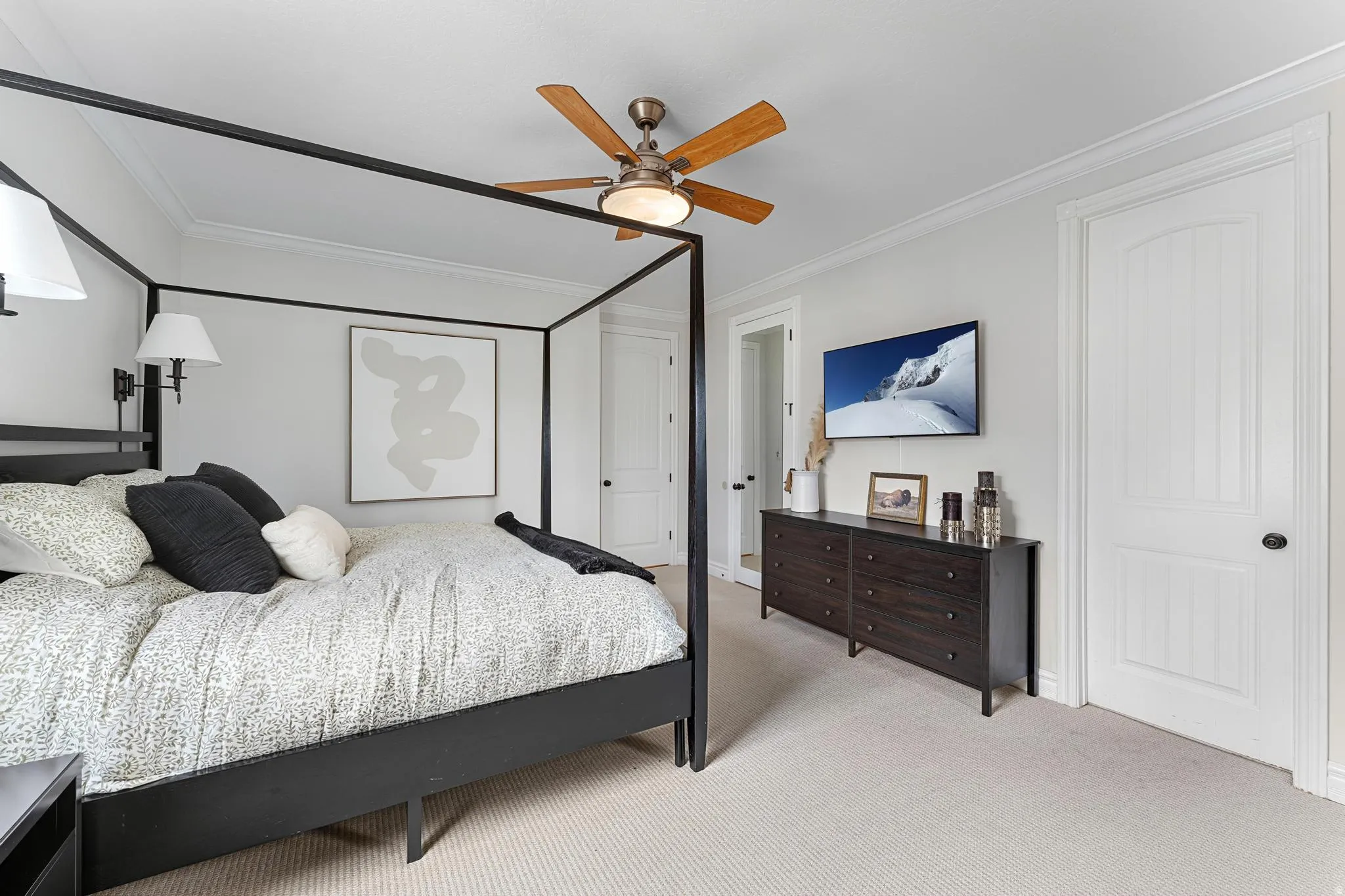 Carpeted bedroom featuring ornamental molding and ceiling fan
