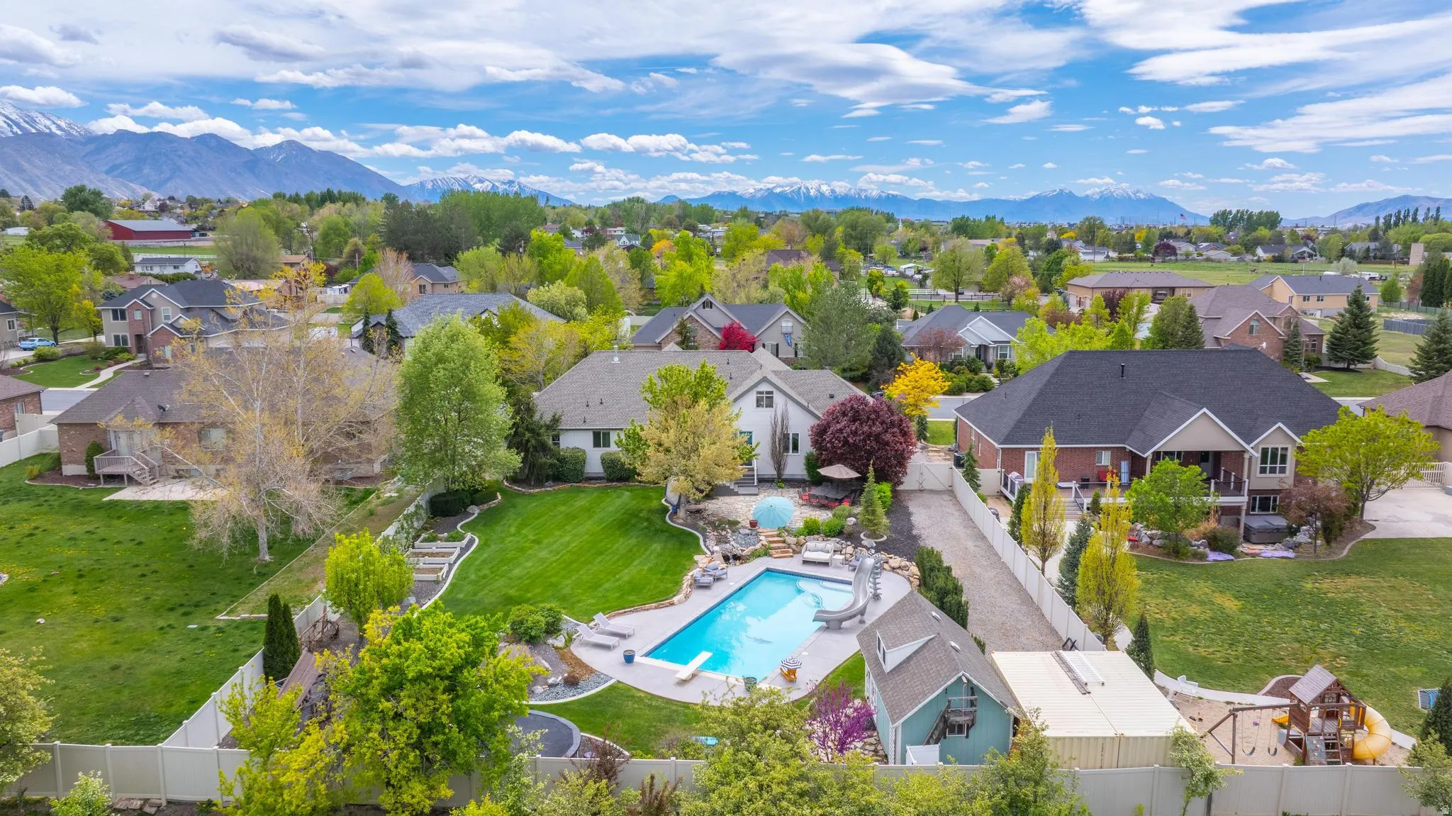 Aerial perspective of suburban area with a pool and a mountainous background