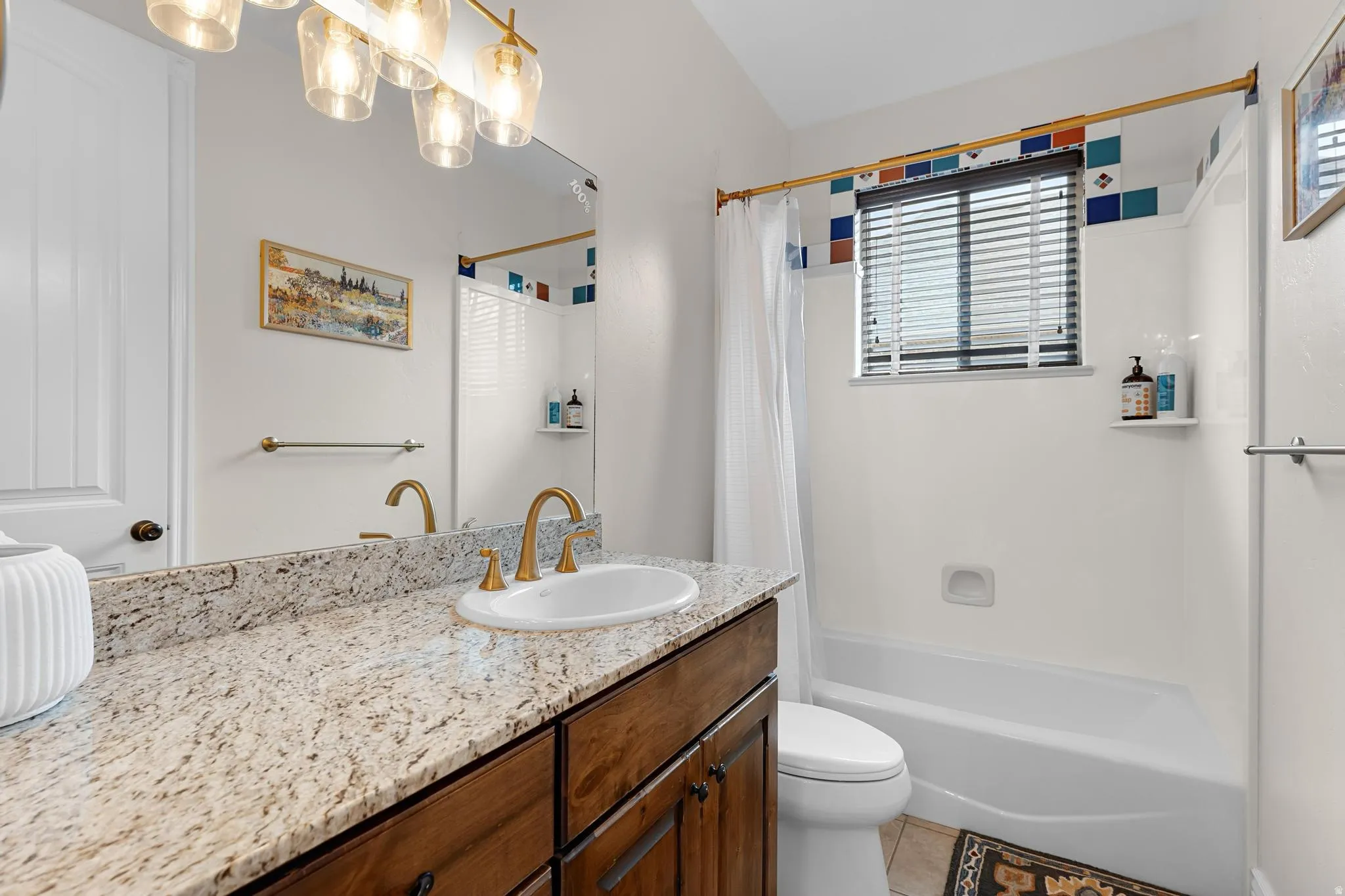 Bathroom with vanity, shower / bath combo with shower curtain, and light tile patterned flooring