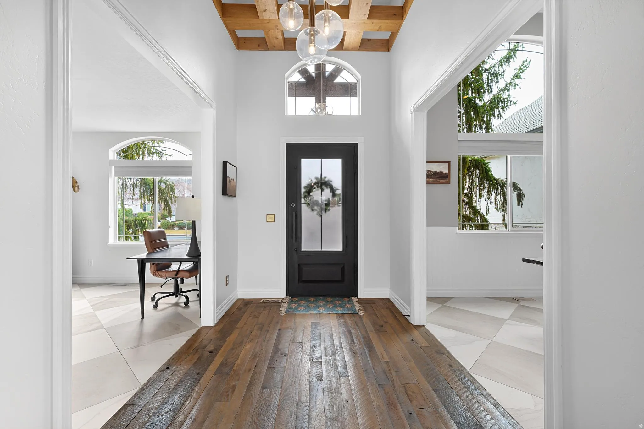 Entrance foyer featuring light tile patterned floors, beam ceiling, and suspended lighting
