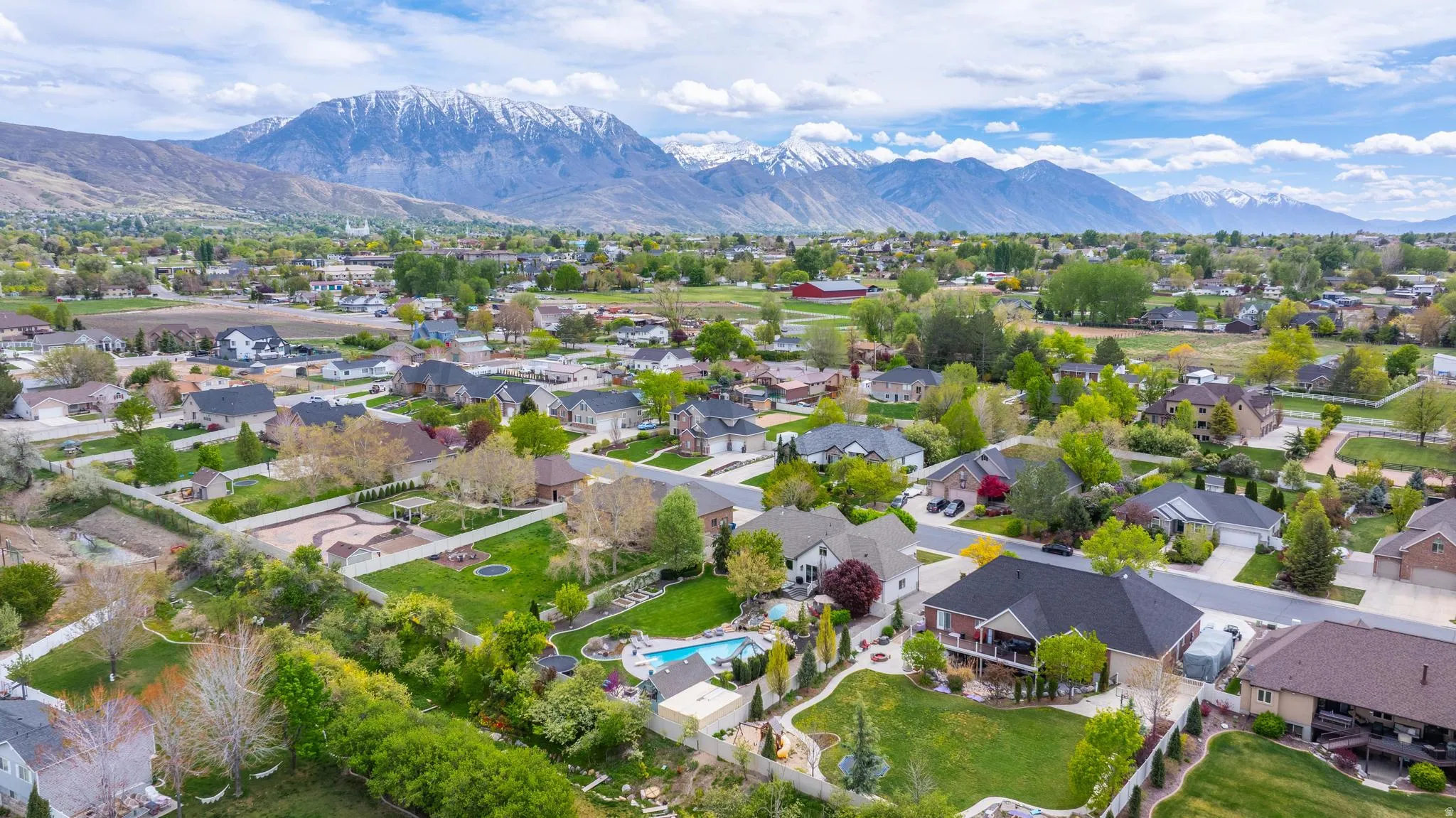 Aerial perspective of suburban area with mountains and a pool
