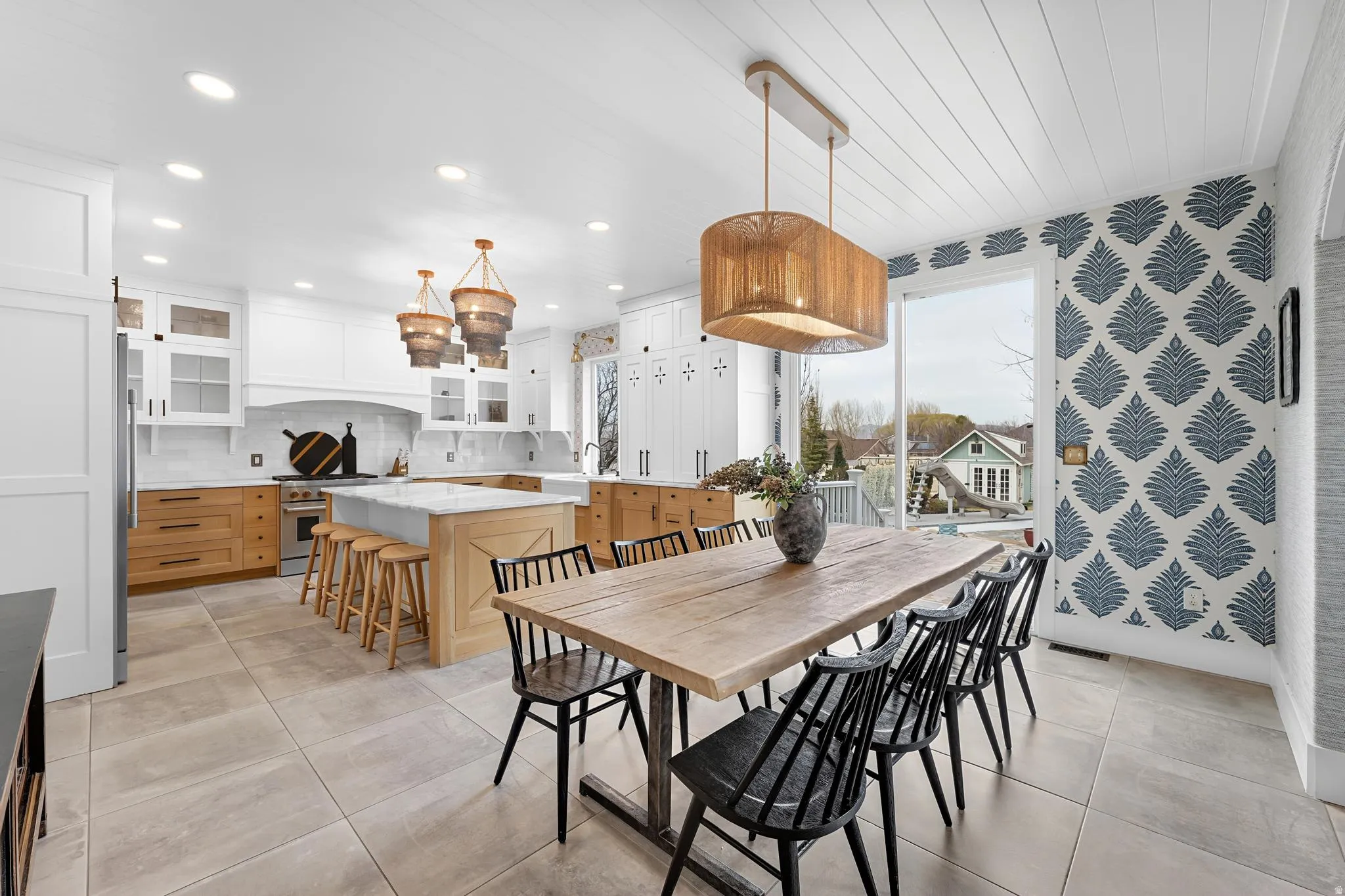 Dining room with light tile patterned floors and wallpapered walls