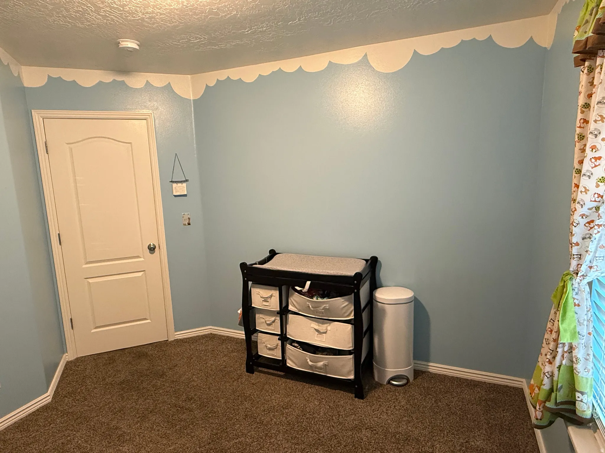 Carpeted bedroom featuring baseboards and a textured ceiling