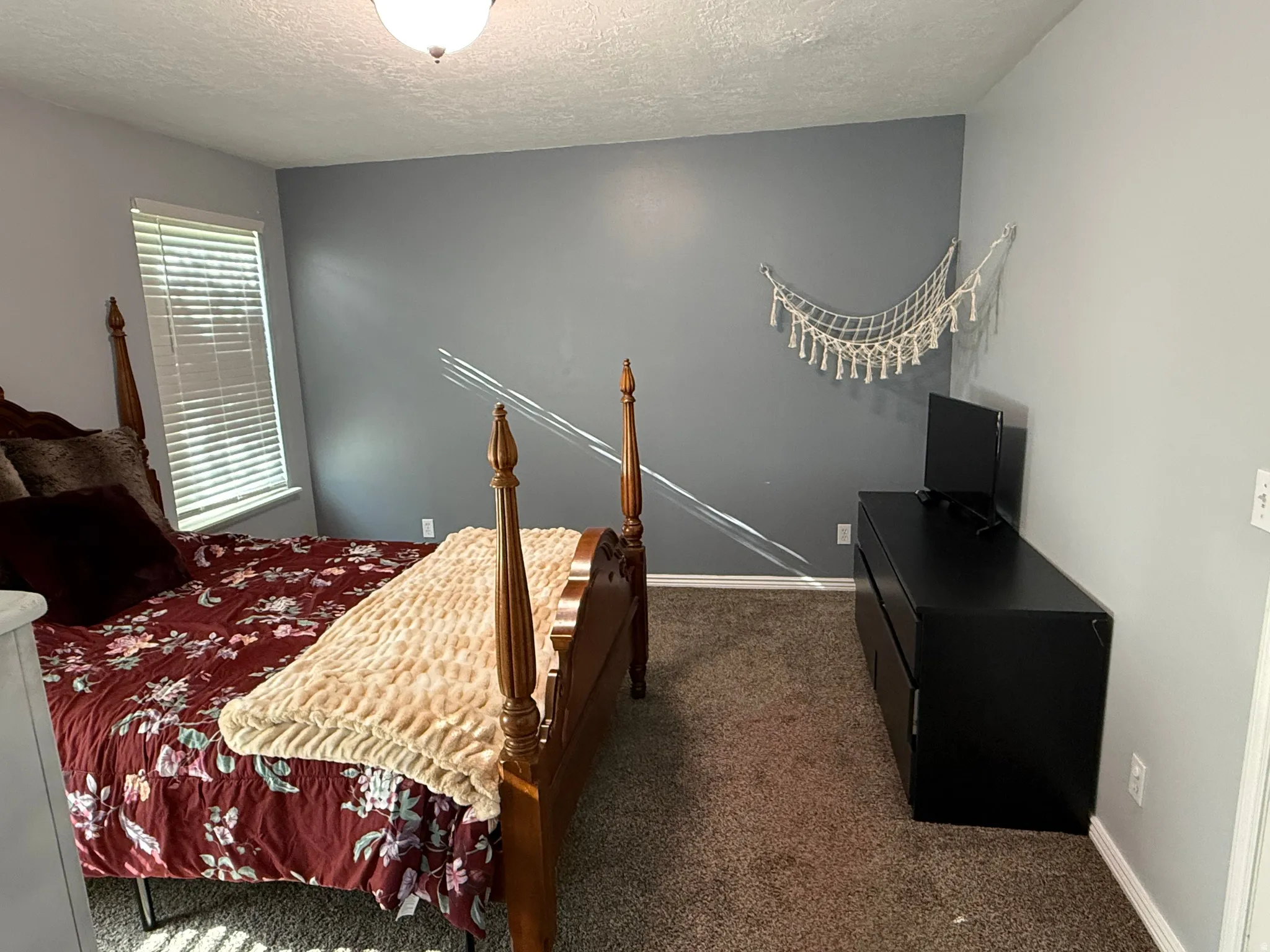 Bedroom featuring dark carpet and a textured ceiling