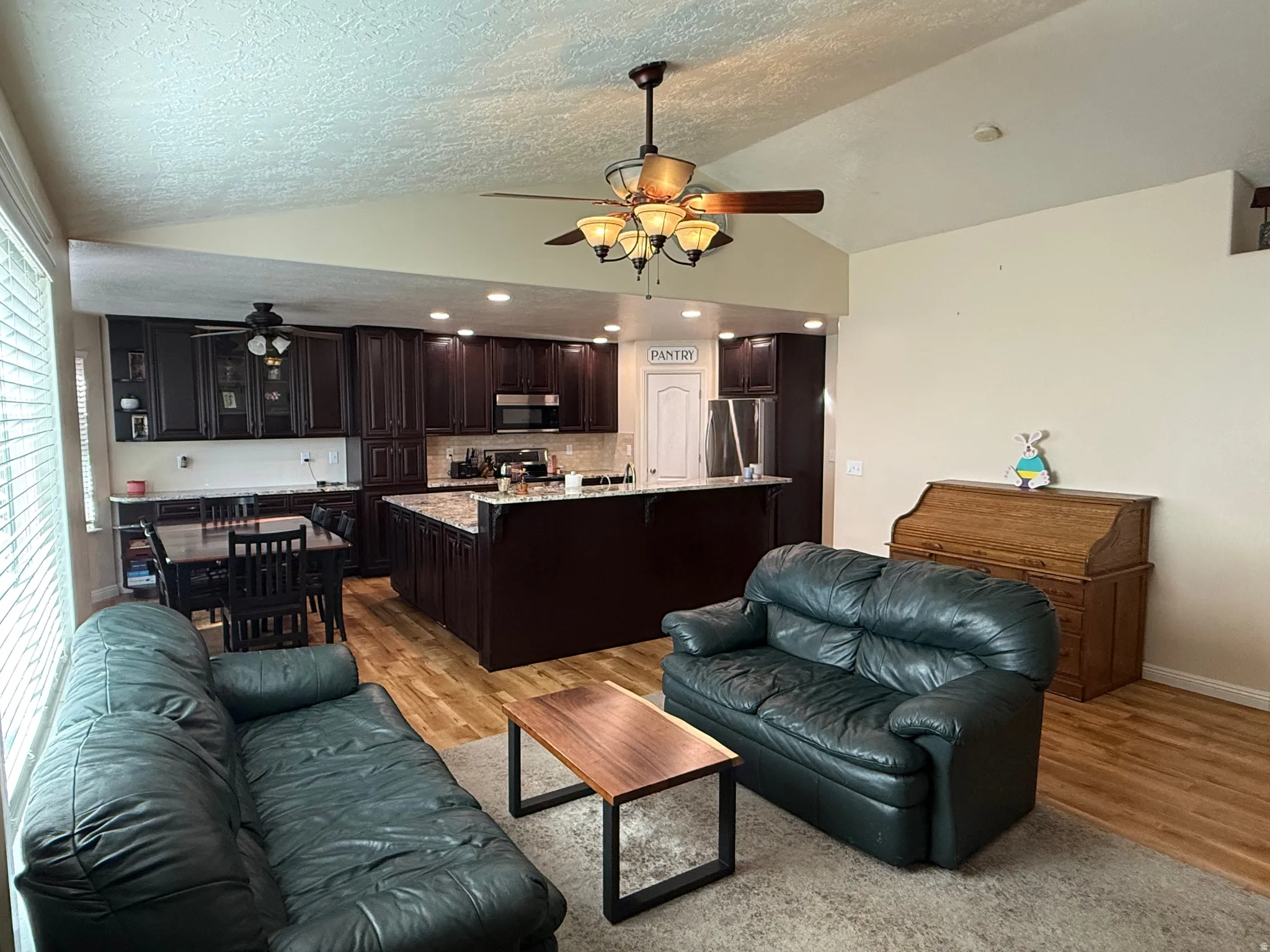 Living area with ceiling fan and light wood-style floors
