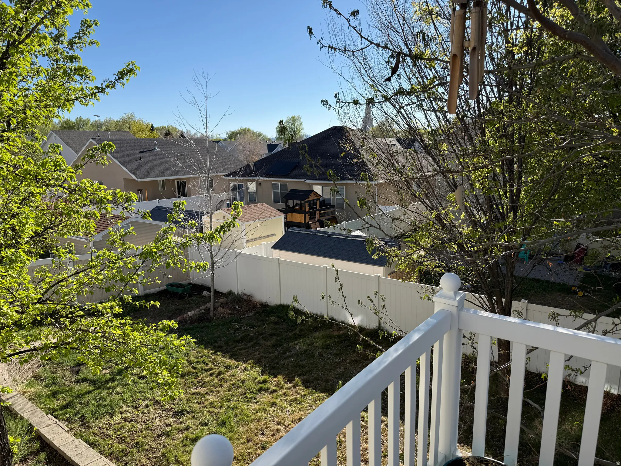 Fenced backyard with a balcony