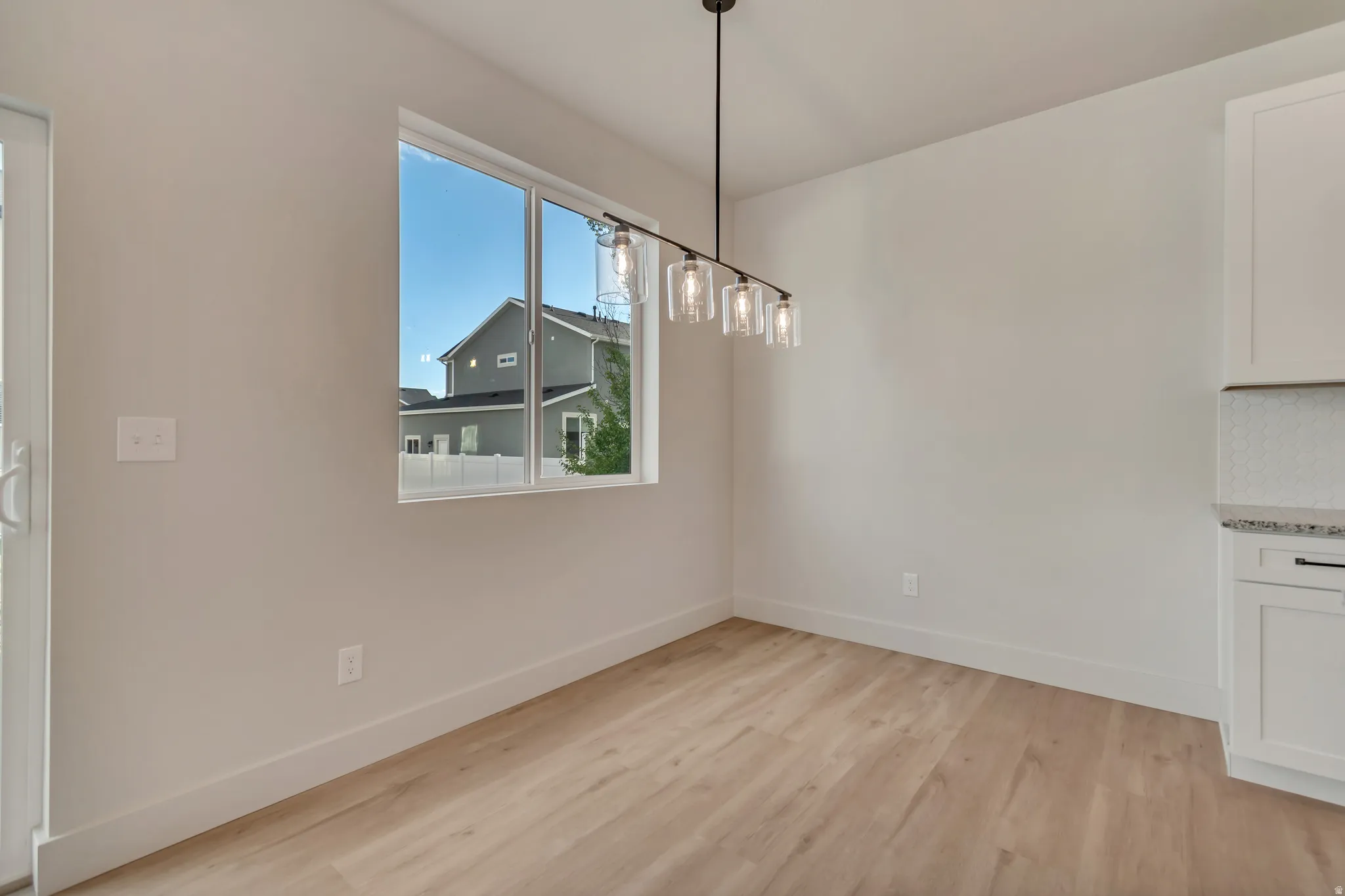 Unfurnished dining area with light wood finished floors and baseboards