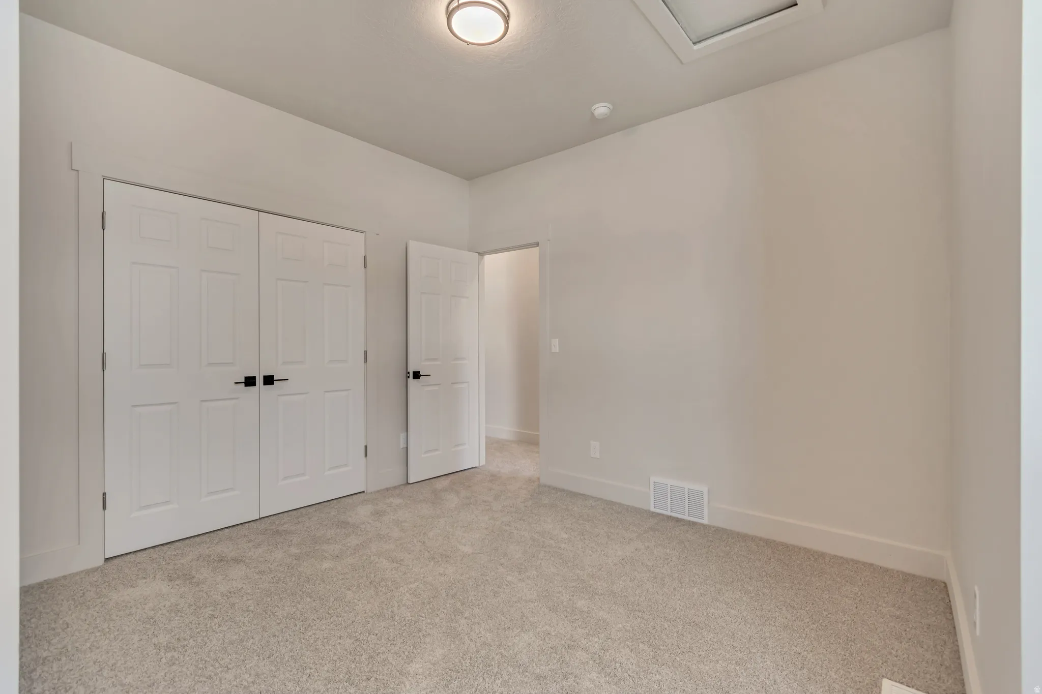 Unfurnished bedroom featuring light colored carpet and a closet
