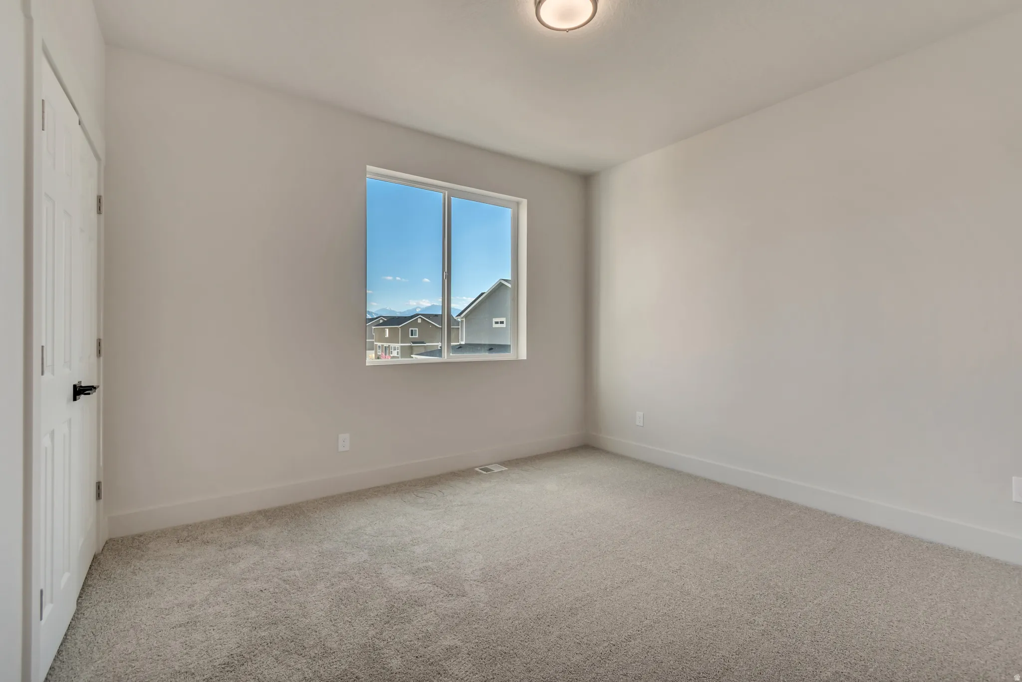 Unfurnished bedroom featuring light carpet and baseboards