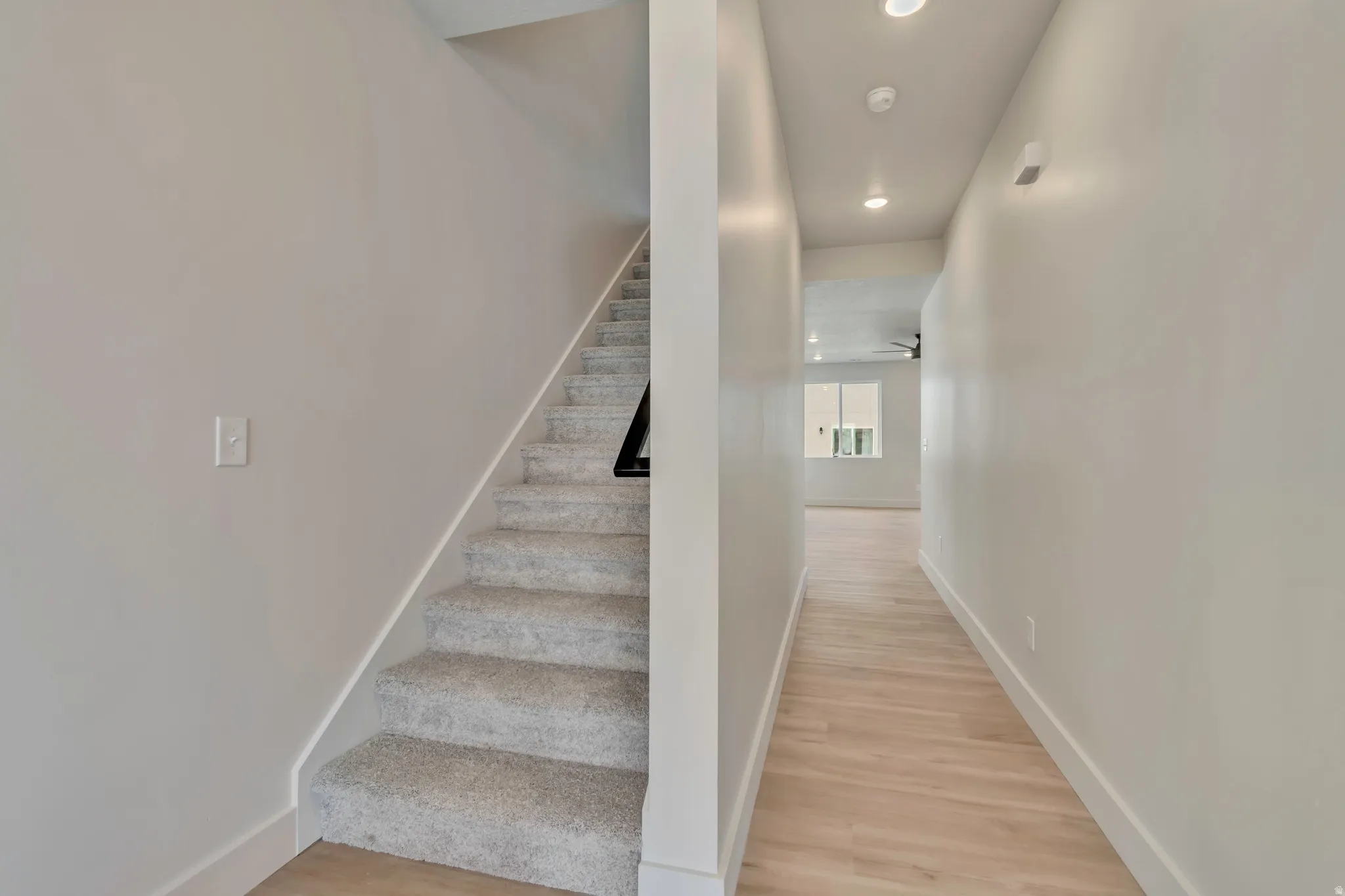 Stairs with wood finished floors and recessed lighting