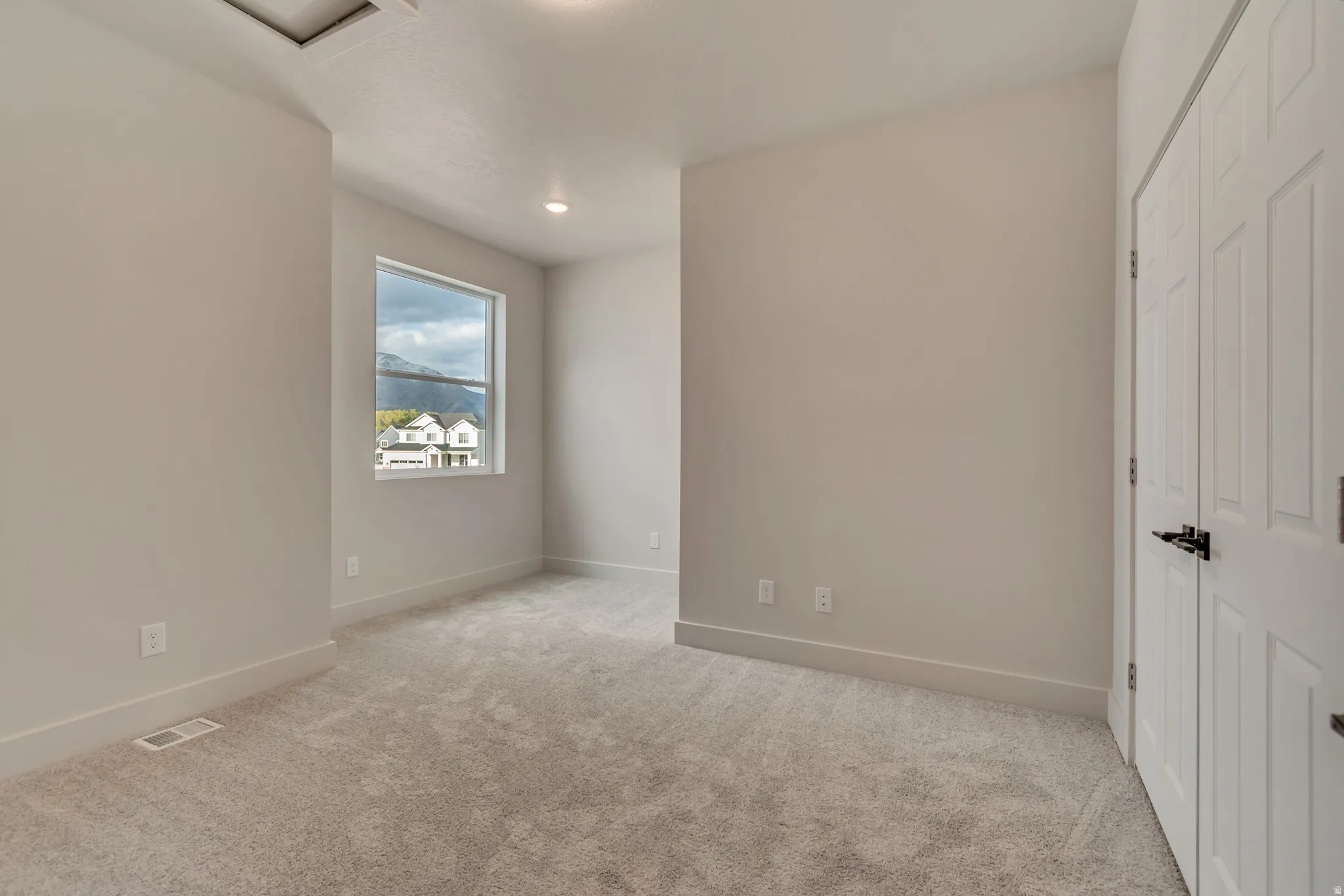 Unfurnished bedroom with a closet, light colored carpet, and recessed lighting