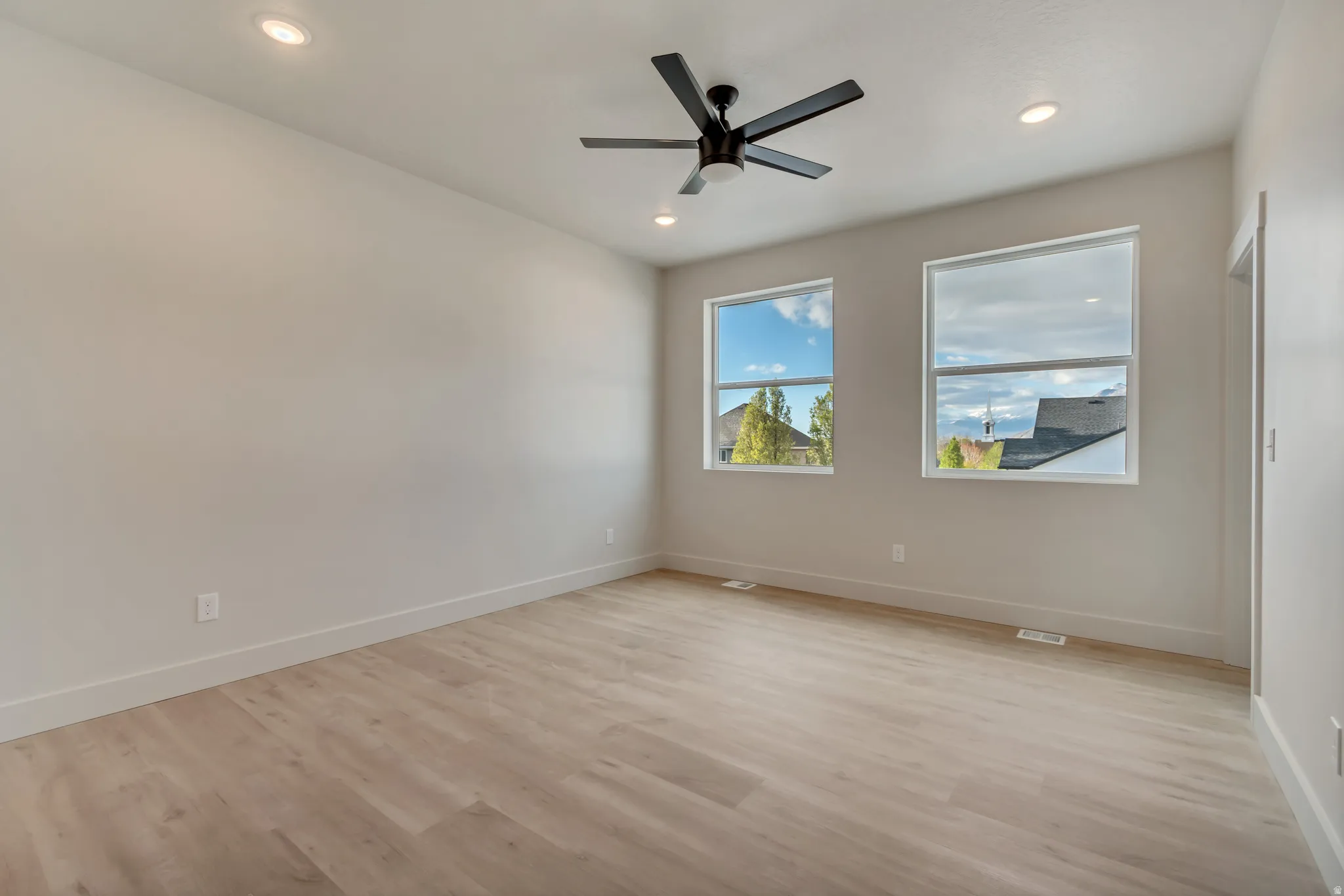 Unfurnished room with light wood-style floors, a ceiling fan, and recessed lighting