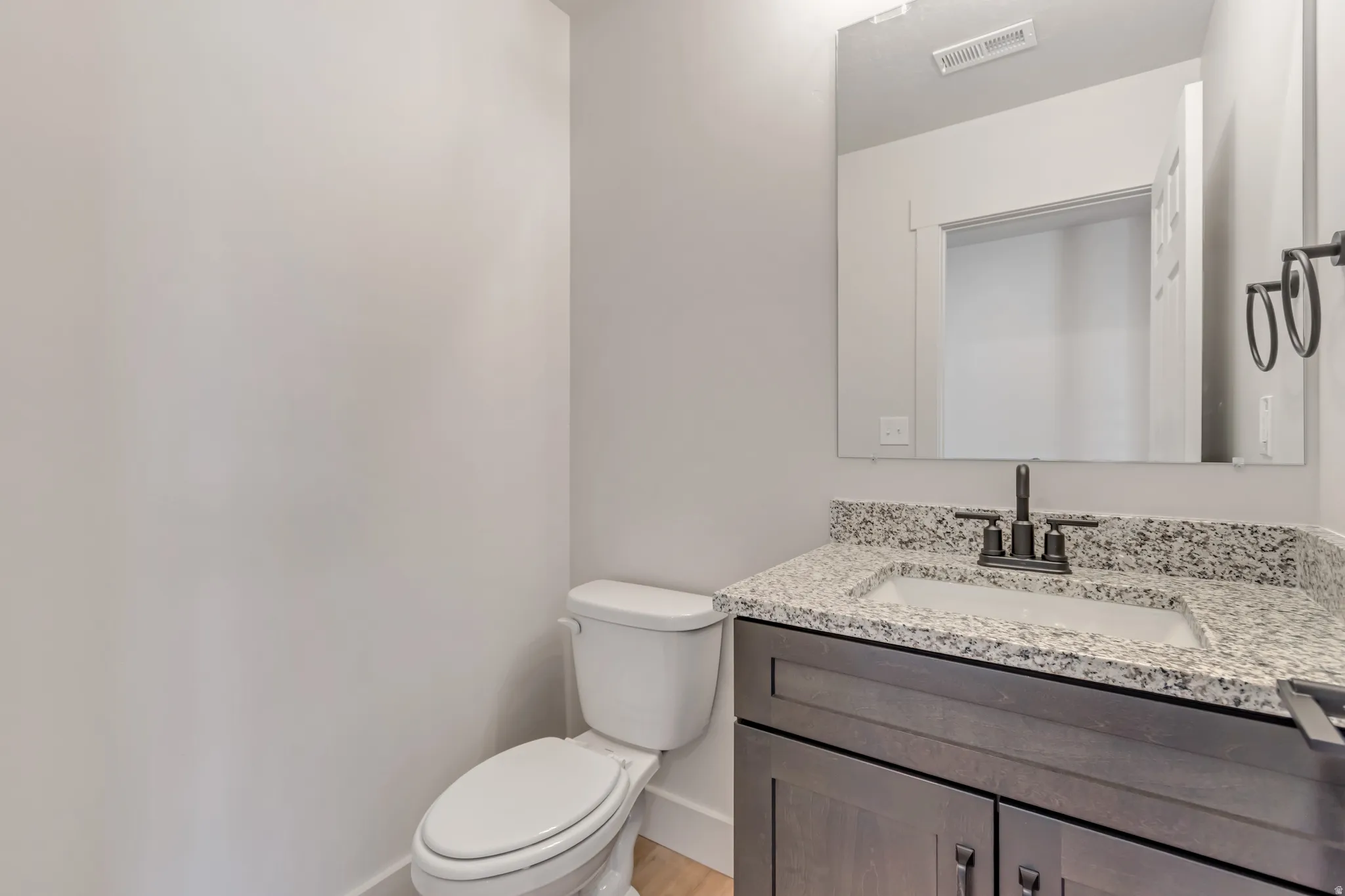 Half bathroom featuring vanity and toilet