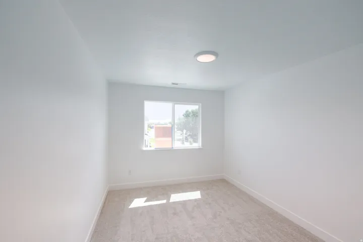 Neutral wall color, wall-to-wall carpeting, recessed ceiling light, double-paned window, and a window sill