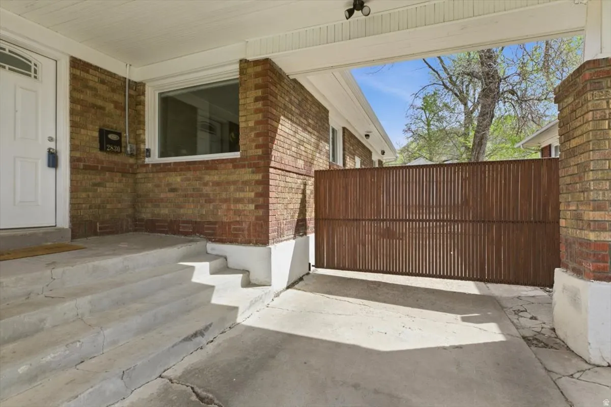 Front Porch to home featuring brick siding, an automatic gate