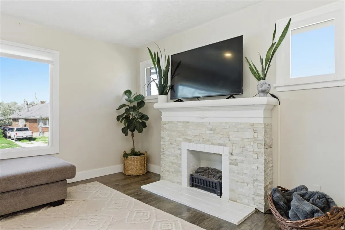 Living area with a stone fireplace, and plenty of natural light