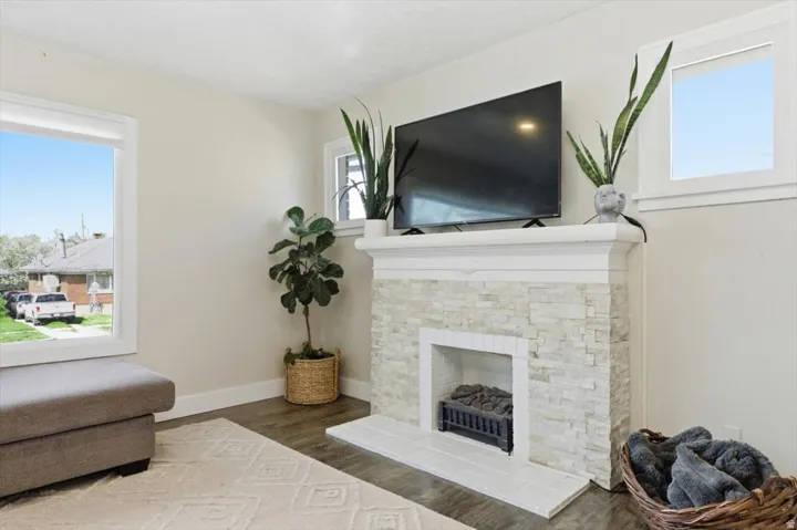 Living area with a stone fireplace, and plenty of natural light
