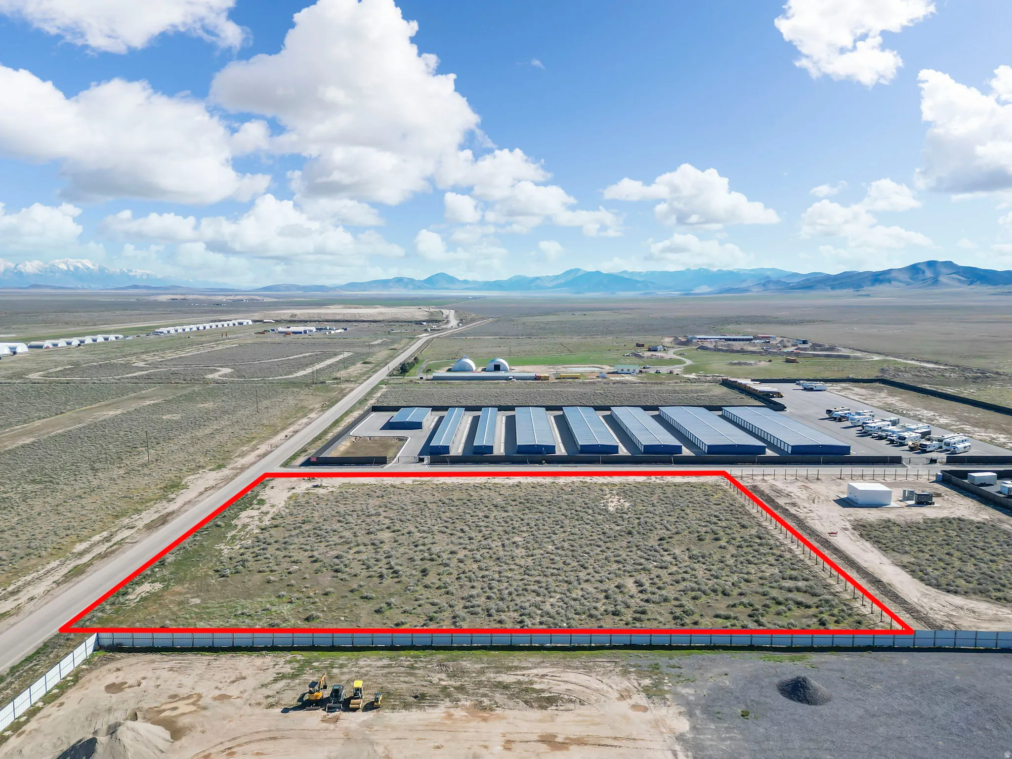 Aerial view of property and surrounding area with property boundaries highlighted and a mountain backdrop