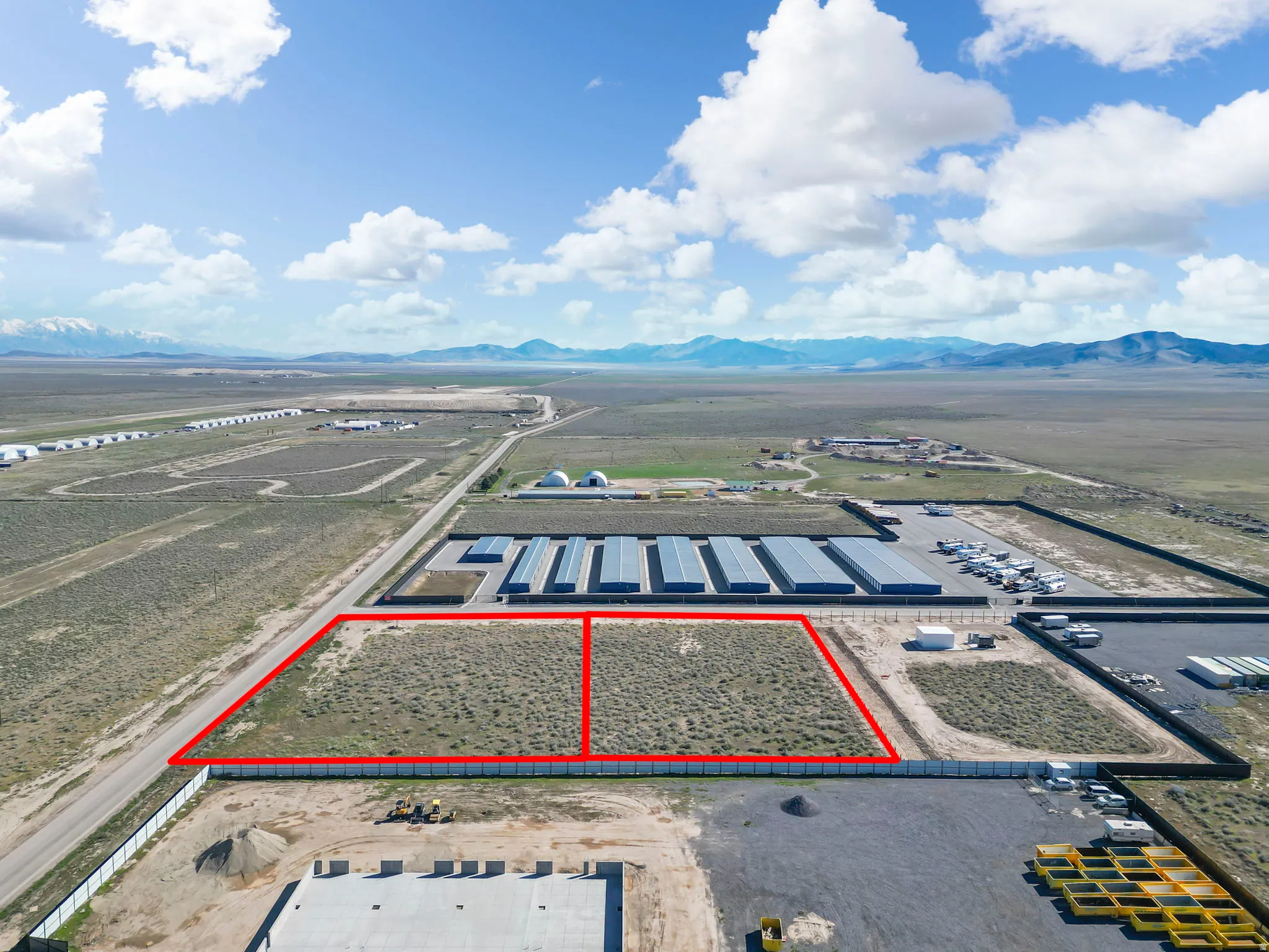 Aerial view of sparsely populated area featuring property parcel outlined and a mountain backdrop
