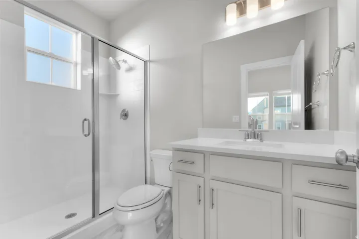 Full bathroom with healthy amount of natural light, vanity, and a stall shower