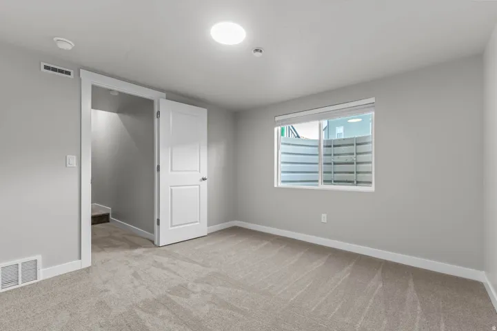 Unfurnished bedroom featuring baseboards and light carpet