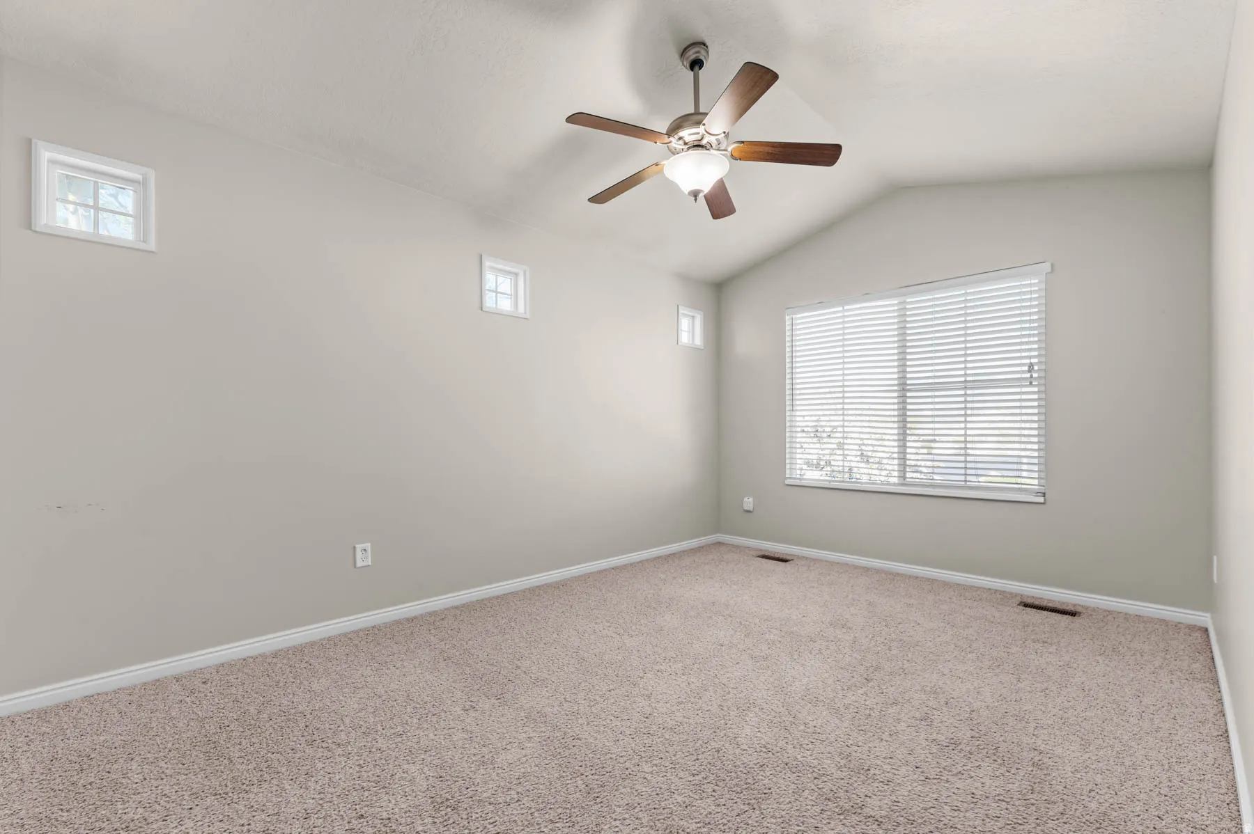 Unfurnished room featuring carpet flooring, lofted ceiling, and a ceiling fan
