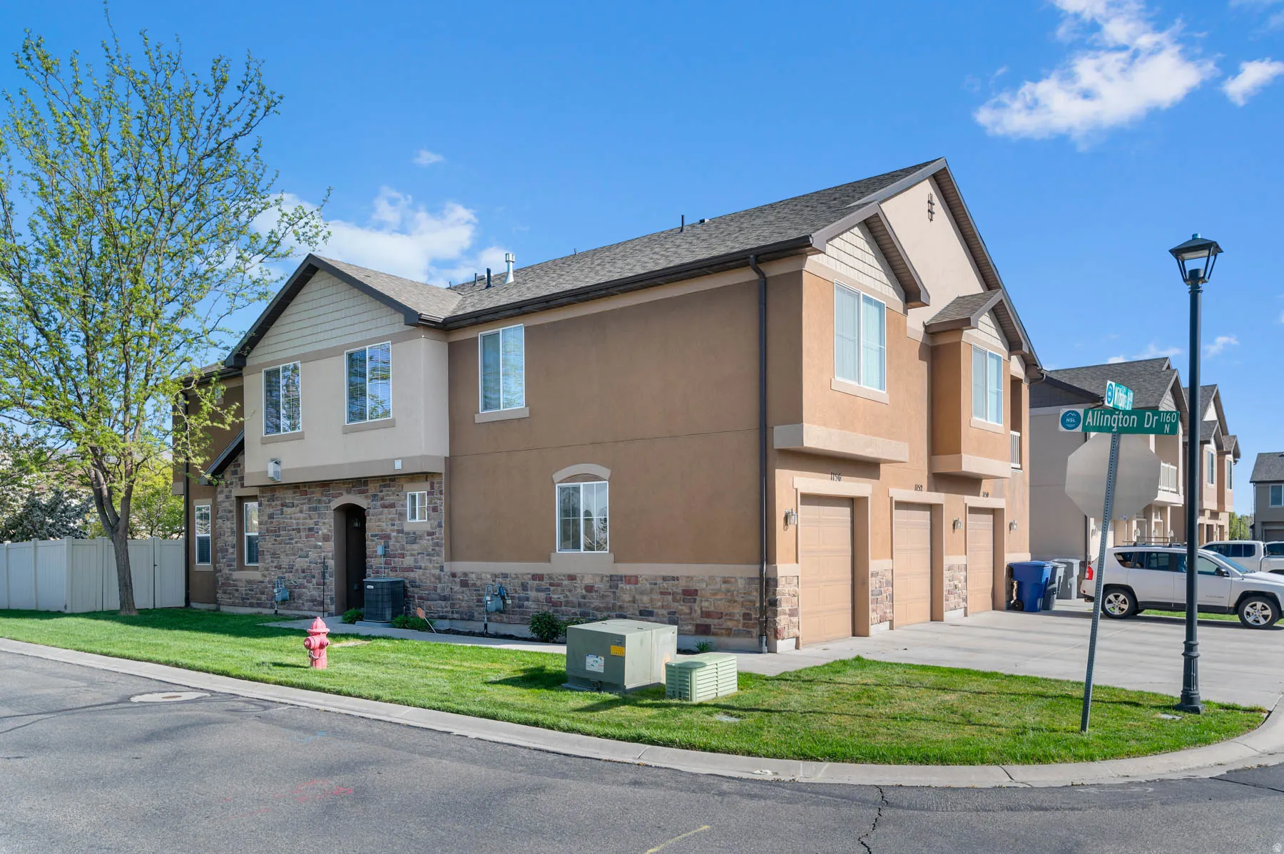 View of front of property featuring stucco siding, stone siding, a garage, and concrete driveway