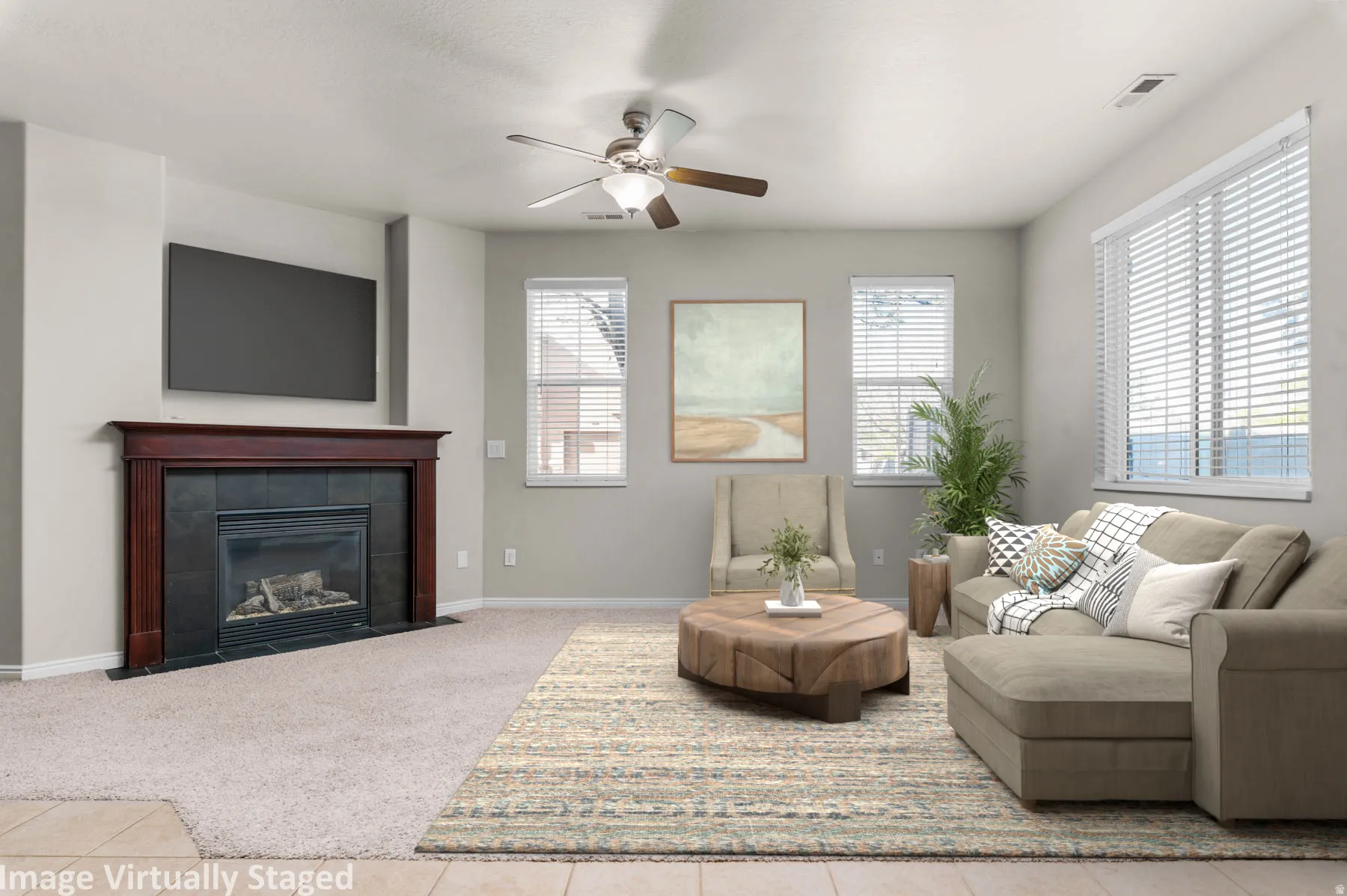 Virtually Staged. Tiled living area with ceiling fan, carpet, and a fireplace