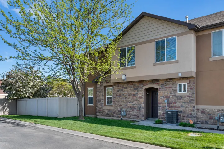 View of front facade featuring stucco siding and stone siding