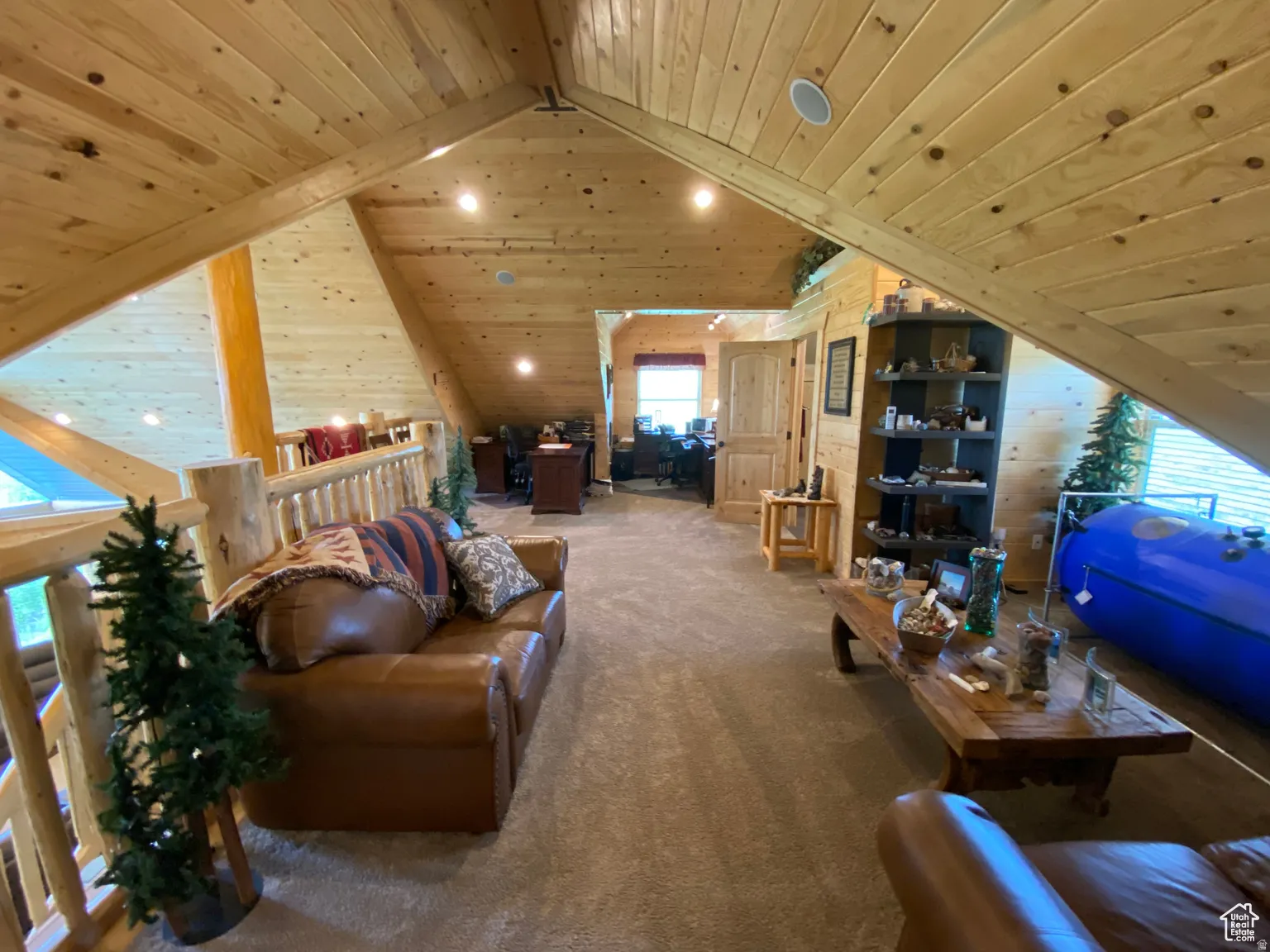 Living room featuring wood ceiling, carpet, and wooden walls